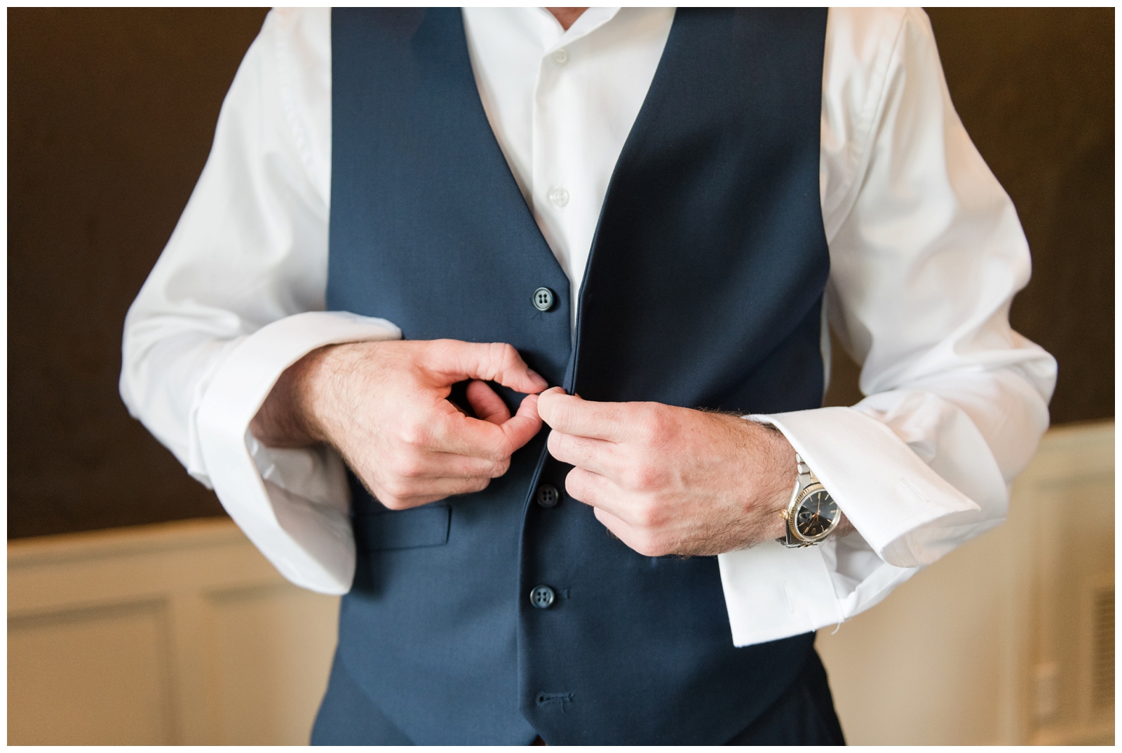 groom buttons up vest of navy suit for Ohio wedding day photographed by Pipers Photography