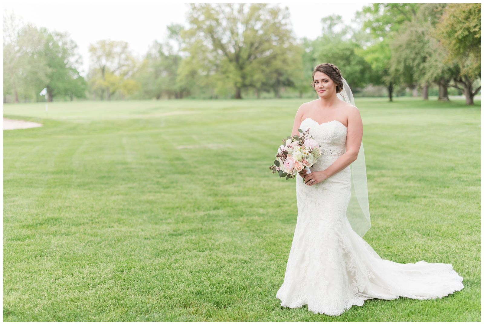 bridal portrait of bride in strapless gown with short veil and peonies in wedding bouquet on green of Brookside Golf and Country Club
