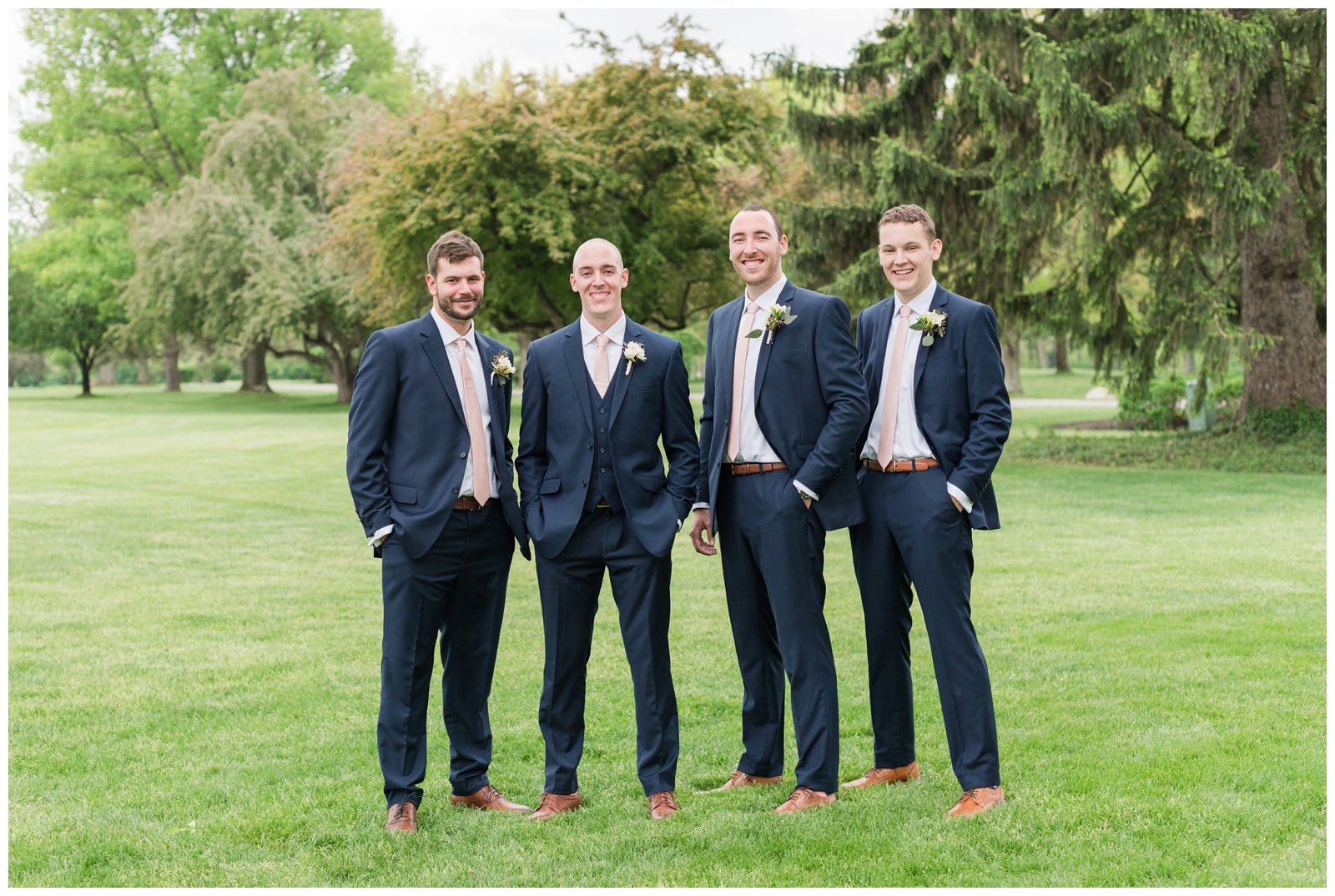 groom and three groomsmen in navy suits pose for Ohio wedding photos