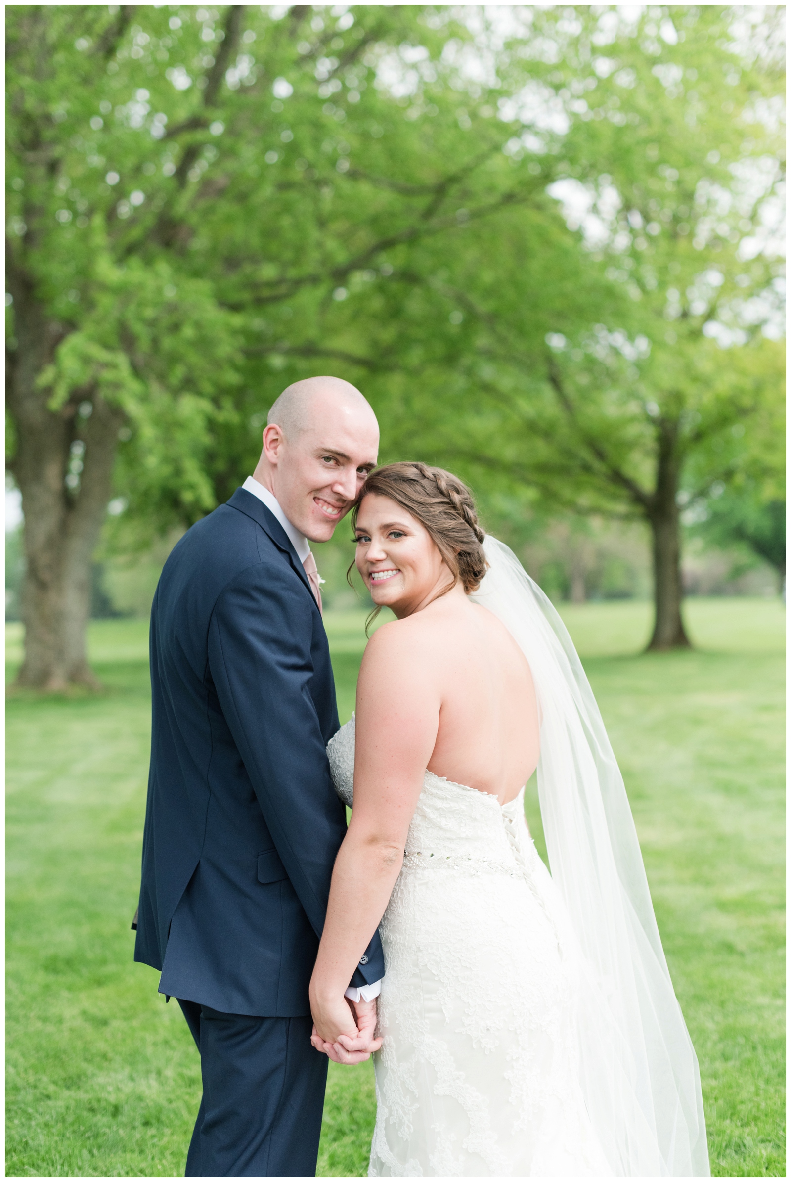 newlyweds pose on green of Brookside Golf and Country Club golf course
