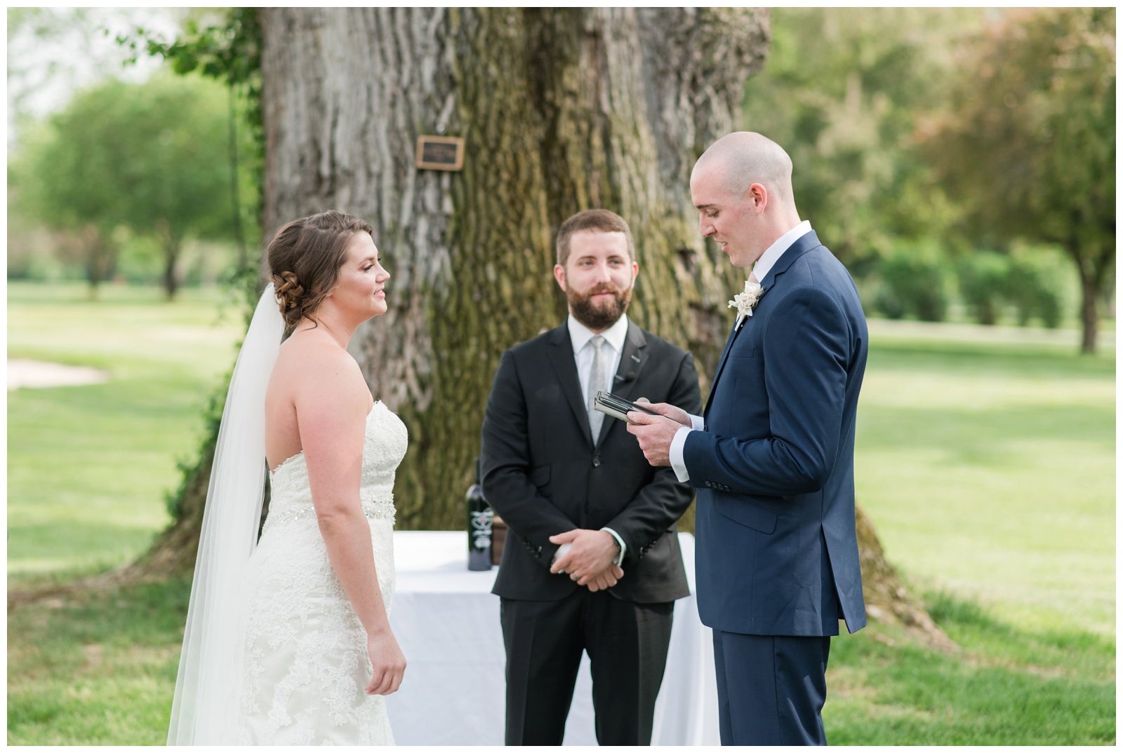 groom reads personal vows to bride in strapless gown with veil during outdoor summer wedding in OH