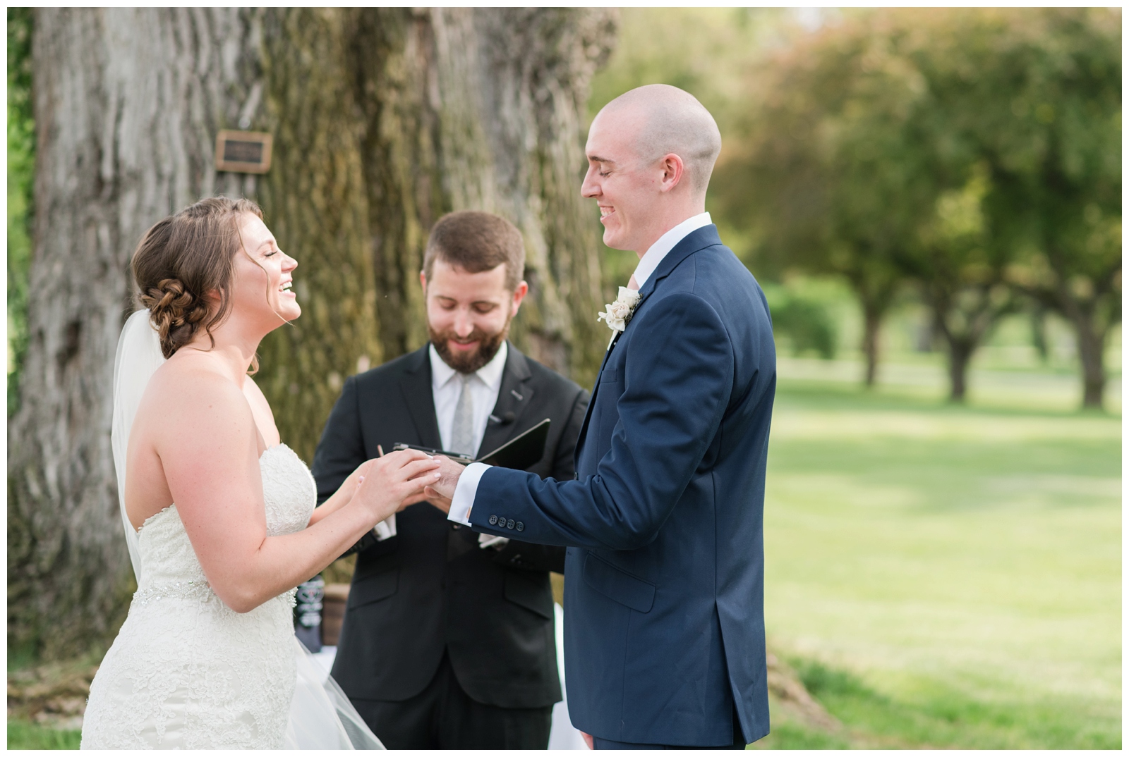 bride and groom exchange vows during wedding ceremony outside on green of Brookside Golf and Country Club
