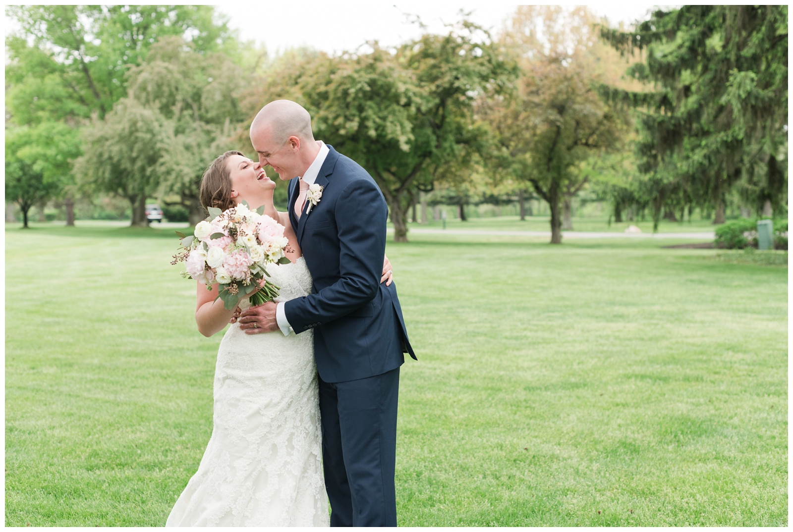 bride and groom touch noses while laughing posing on the green at Brookside Golf and Country Club