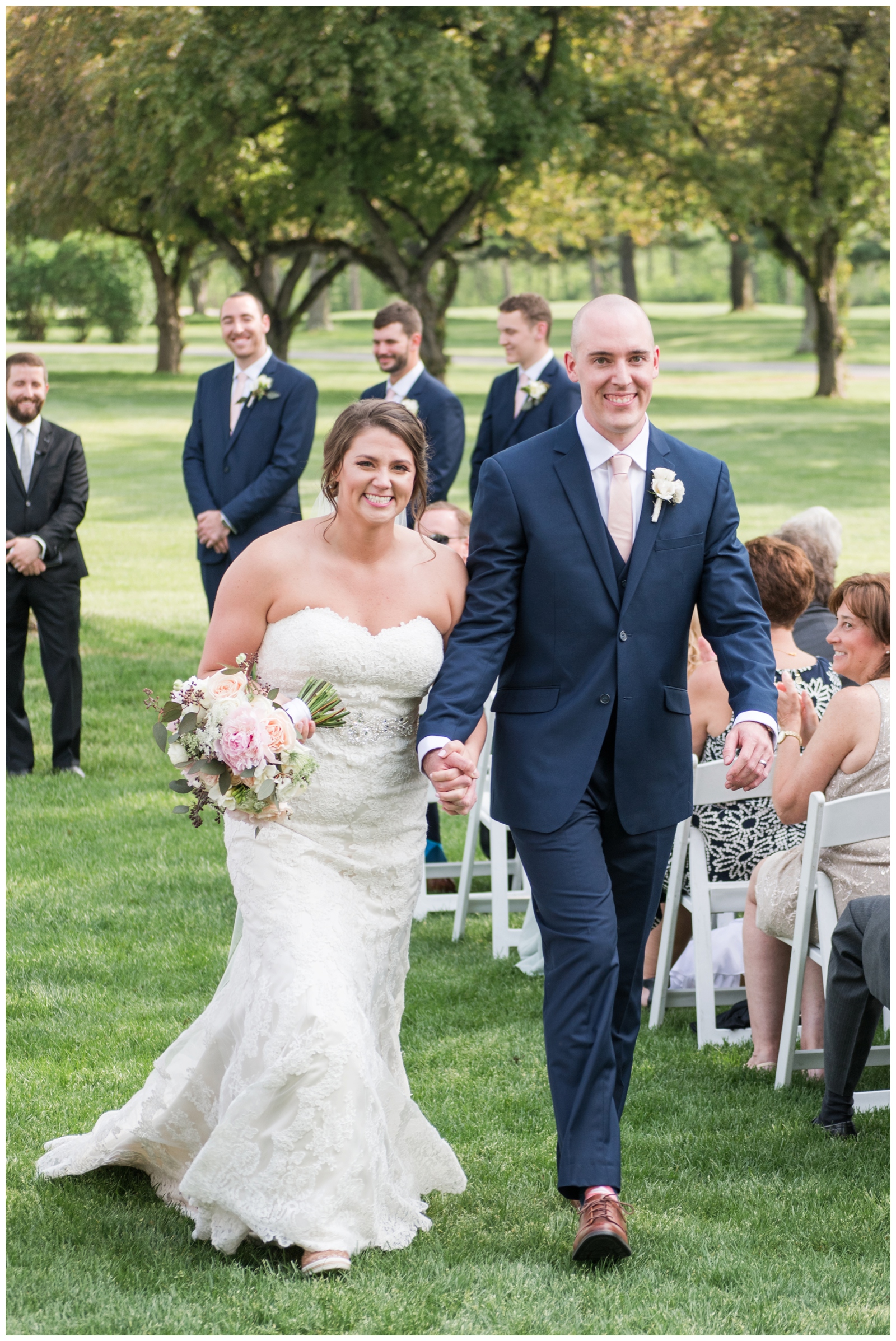 bride and groom walk up aisle after getting married at Brookside Golf and Country Club