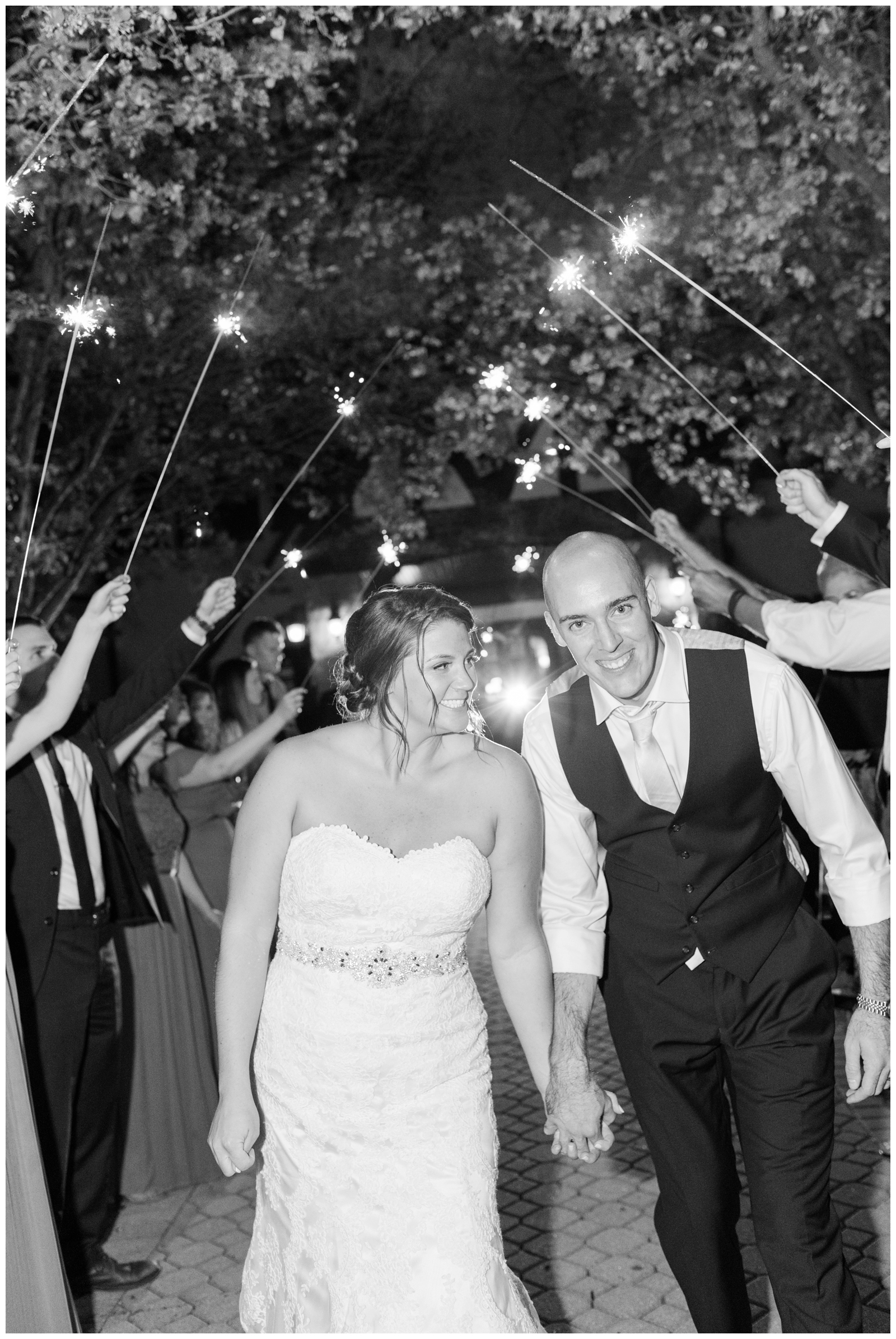 bride and groom hold hands walking through sparkler exit at Brookside Golf and Country Club