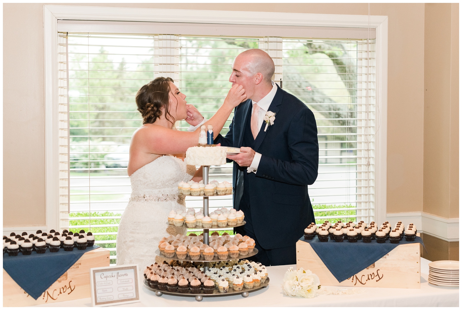 bride and groom feed each other cupcakes from Polkadot Cupcakery