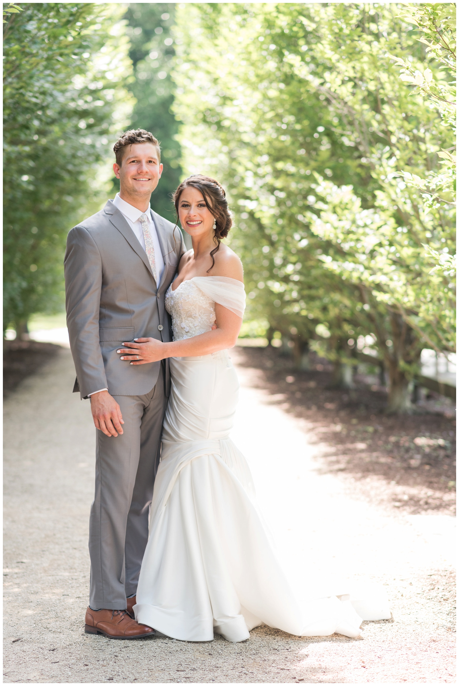 groom in grey suit holds bride in off-the-shoulder wedding dress at Columbus OH wedding venue