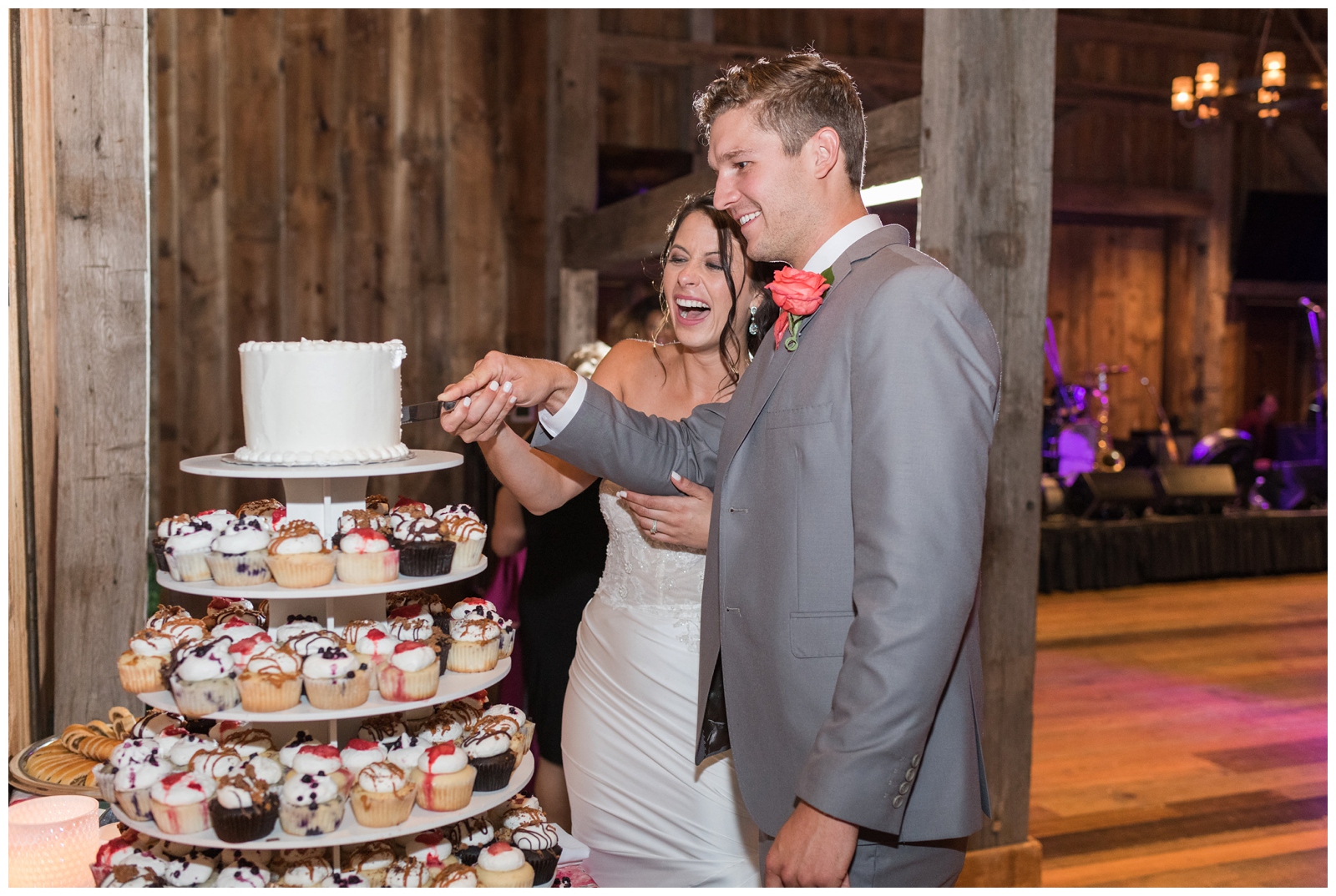 bride and groom cut top cake tier of cupcake tower at wedding reception in Columbus OH