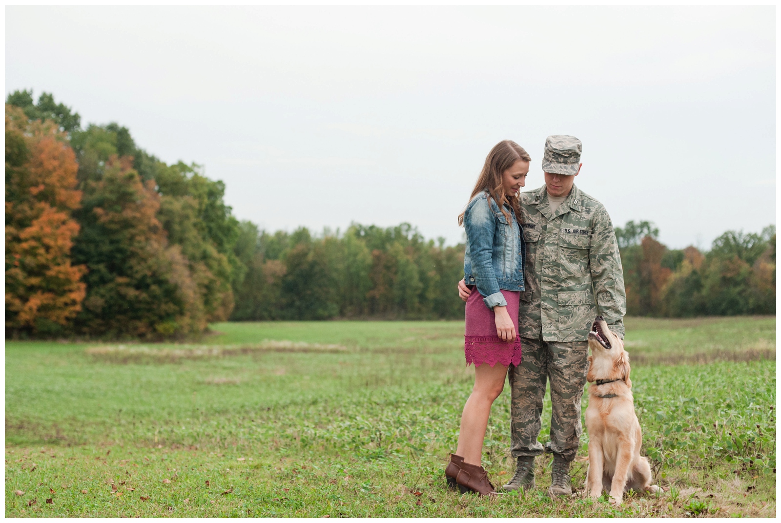 engaged girl and boy looking a their golden lab dog during their country fall engagement session in sunbury ohio