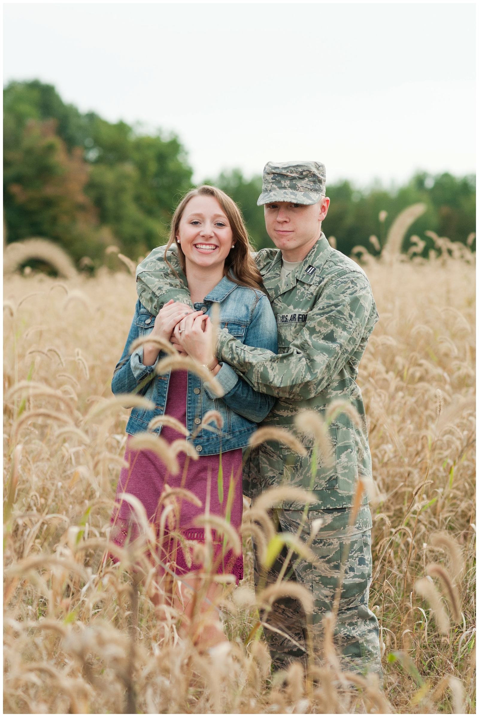 fiancé is hugging fiancée during their engagement session in the country in a wheat field 