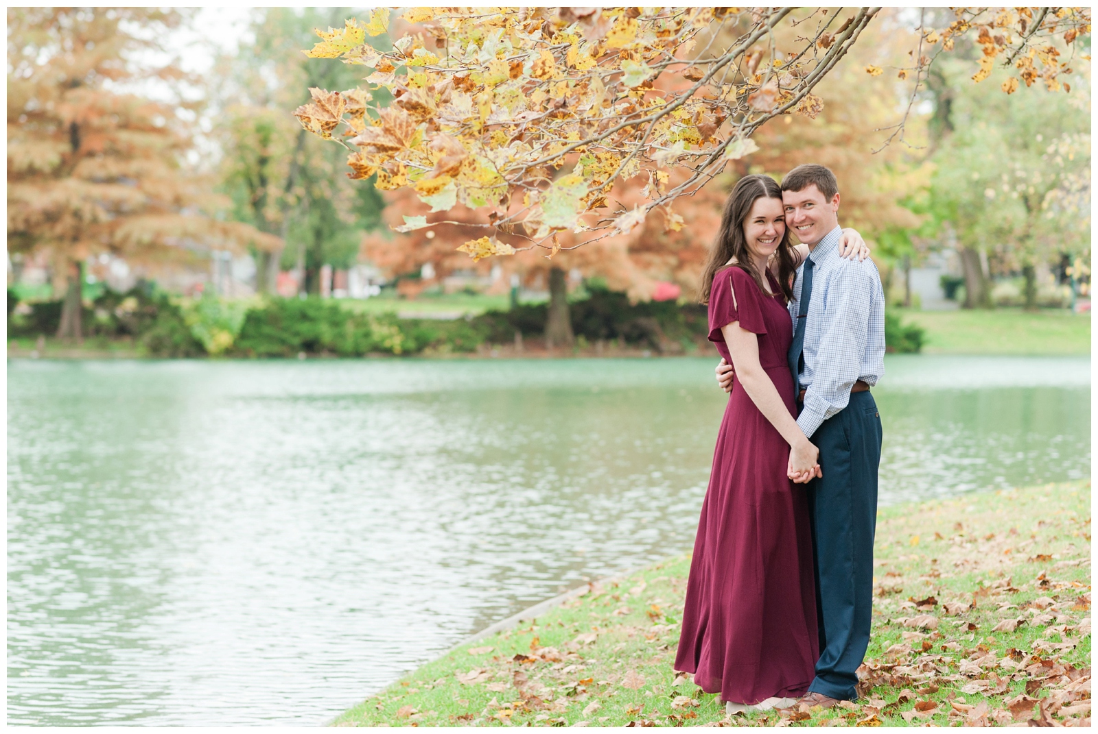 Beautiful fall Franklin Park Conservatory Engagement Session Girl in burgundy dress and guy in suit stand looking at the camera 