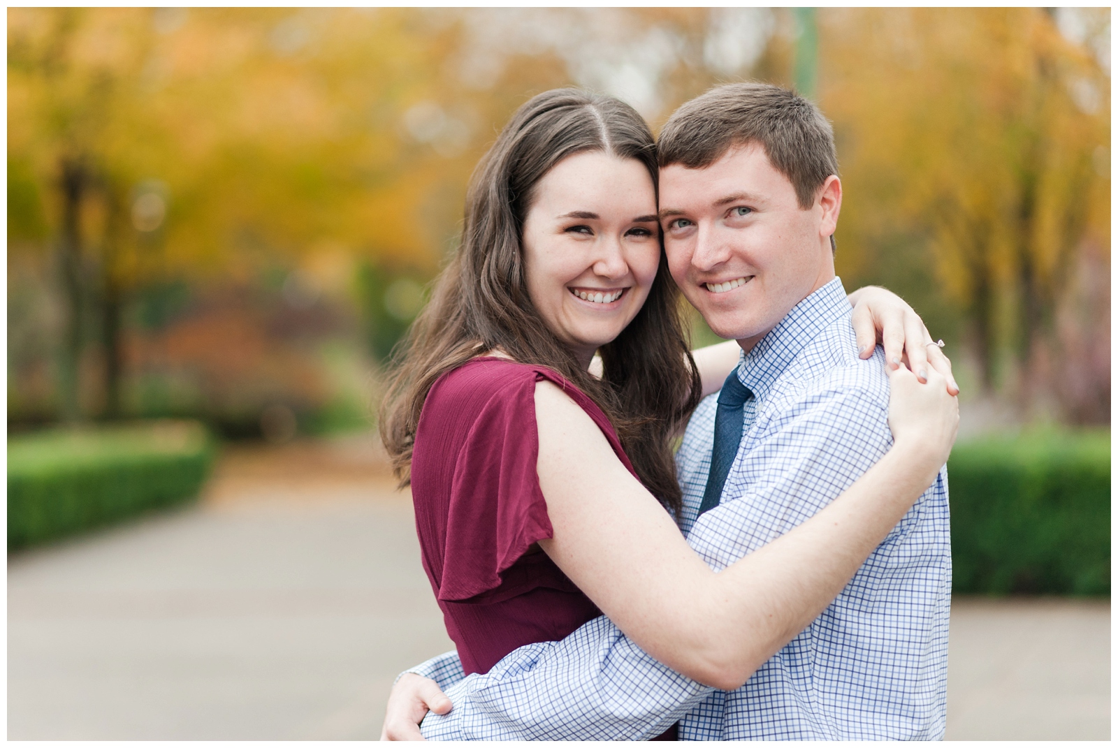 girl and boy looking at camera smiling at Beautiful fall Franklin Park Conservatory Engagement Session