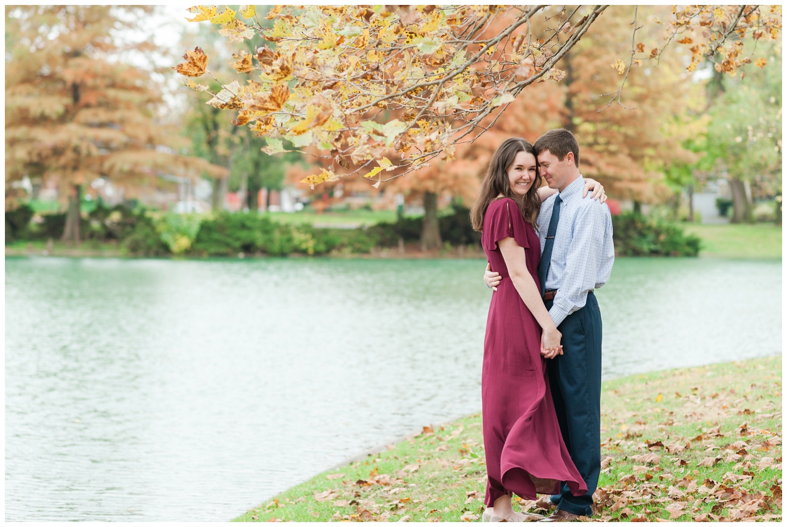 engaged man looking at his fiancé during their beautiful fall engagement photos at franklin park conservatory in downtown columbus ohio with a pond behind them 