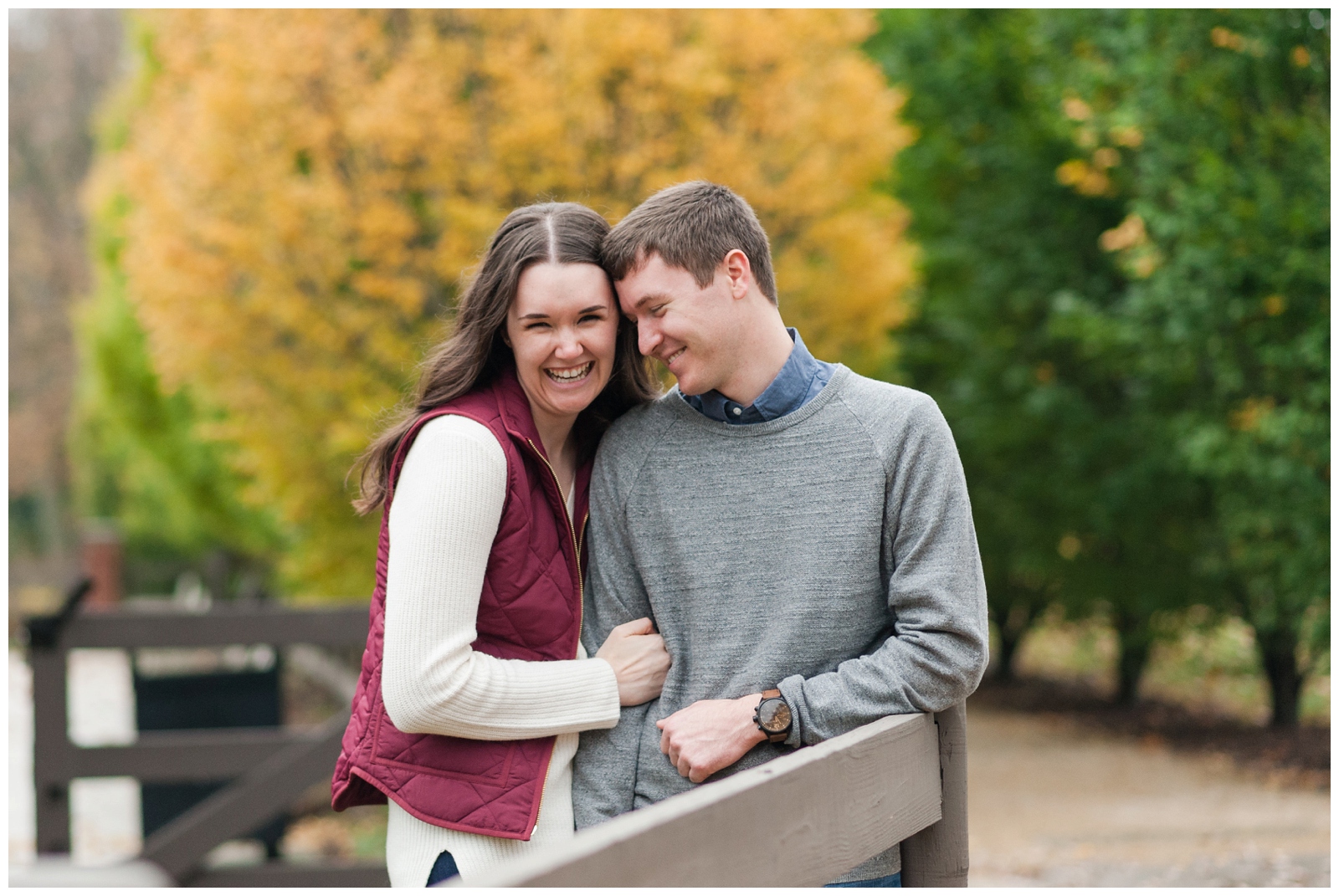 engaged girl joyfully laughing with her fiancé on a crisp fall day at franklin park conservatory during their engagement photos 