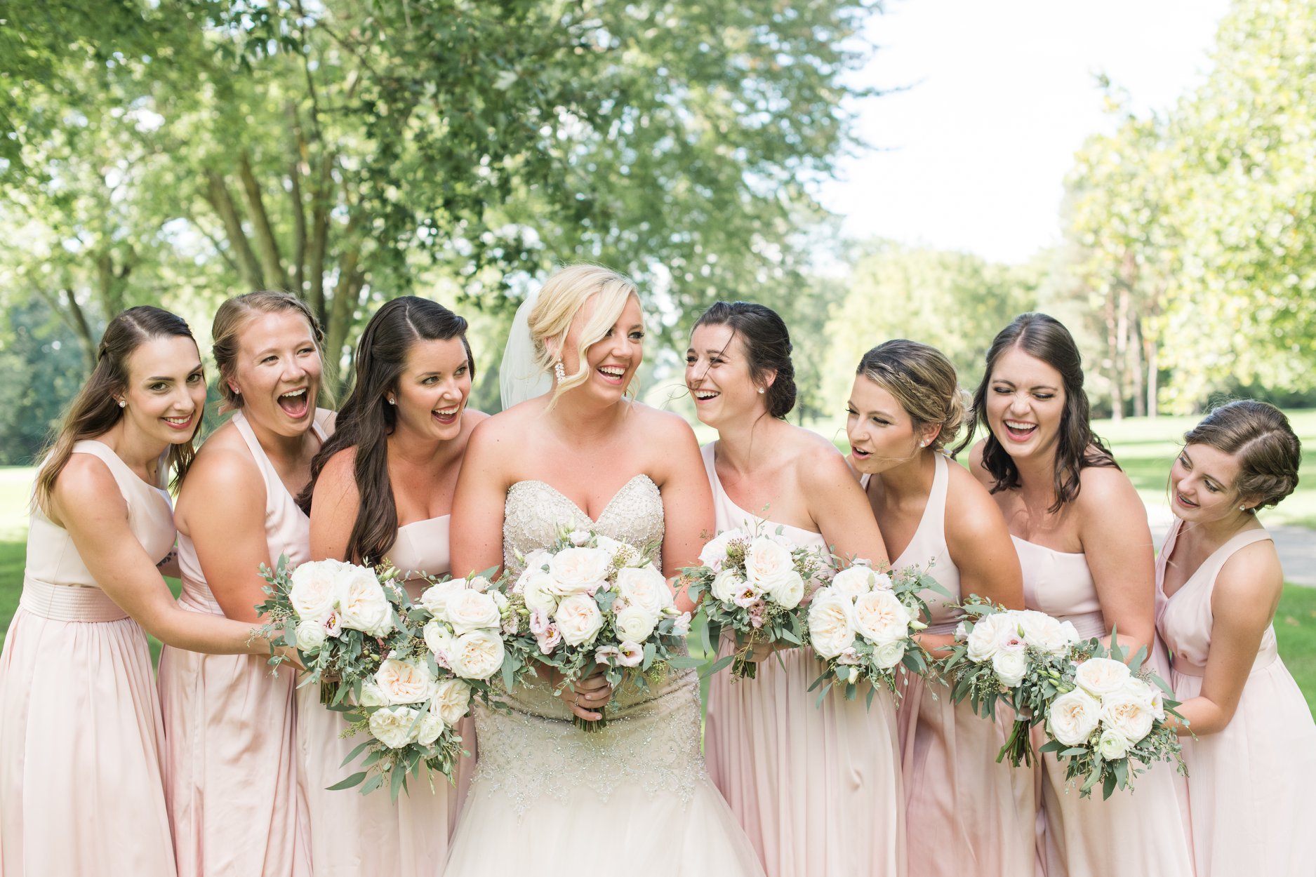 bride with her bridesmaids laughing and smiling together brookside golf and country club in columbus ohio columbus ohio luxury wedding photographer