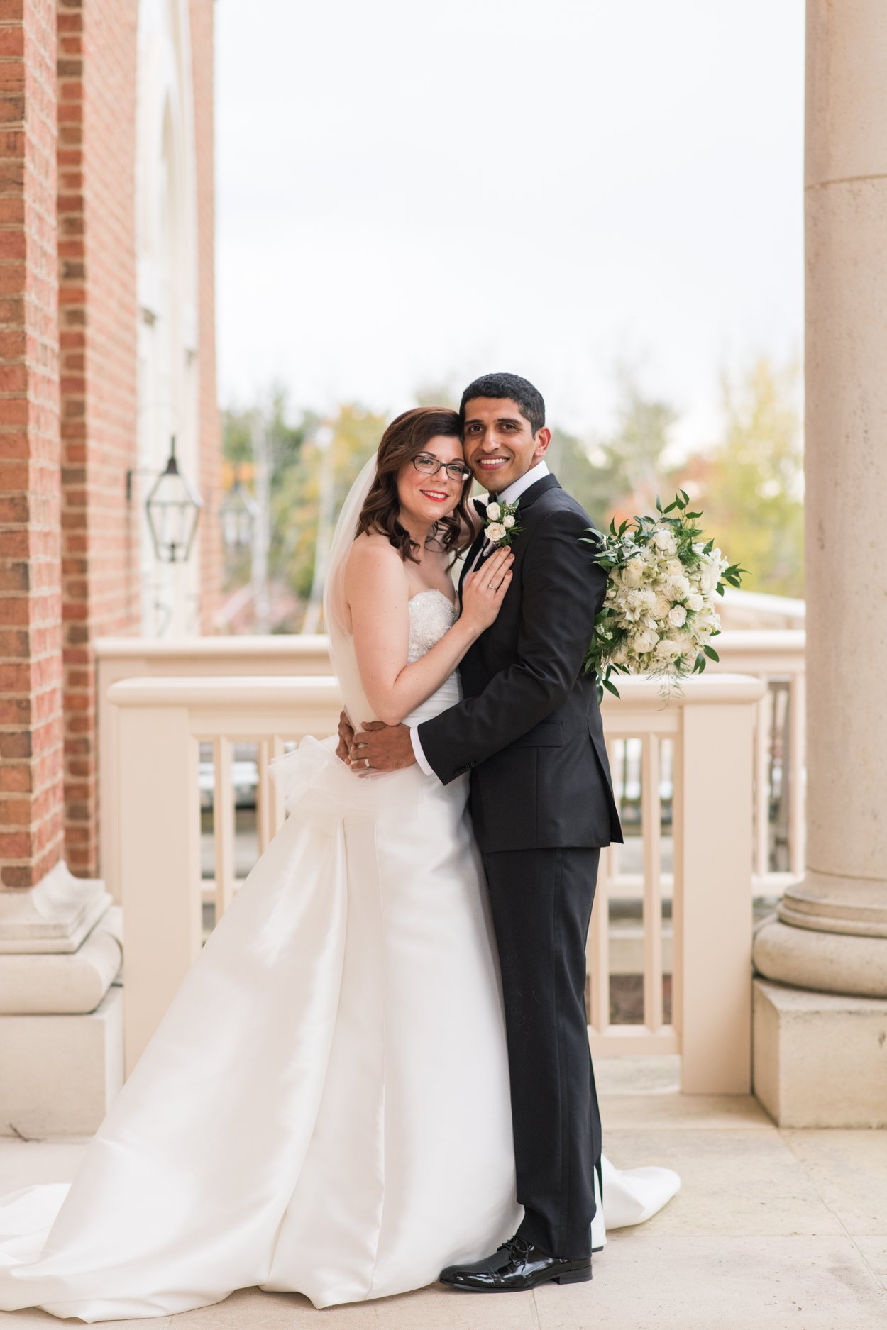 bride and groom smiling at the camera for an elegant formal photo on their wedding day at the new albany country club 