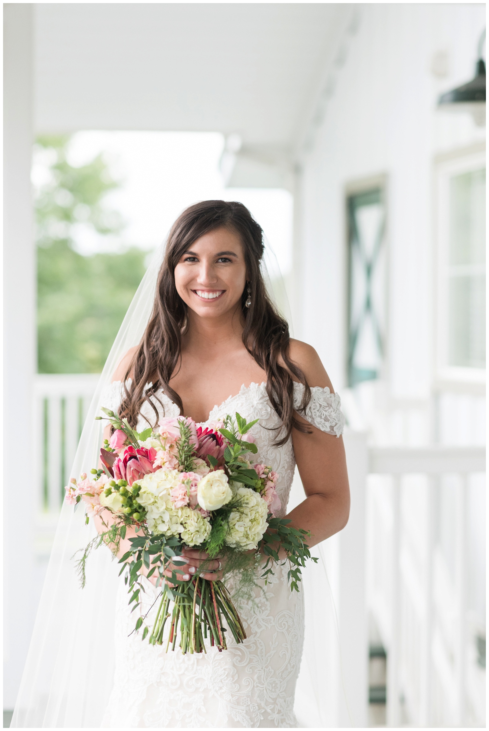 bride smiling at the camera holding her wedding bouquet at irongate equestrian center in hartford ohio 