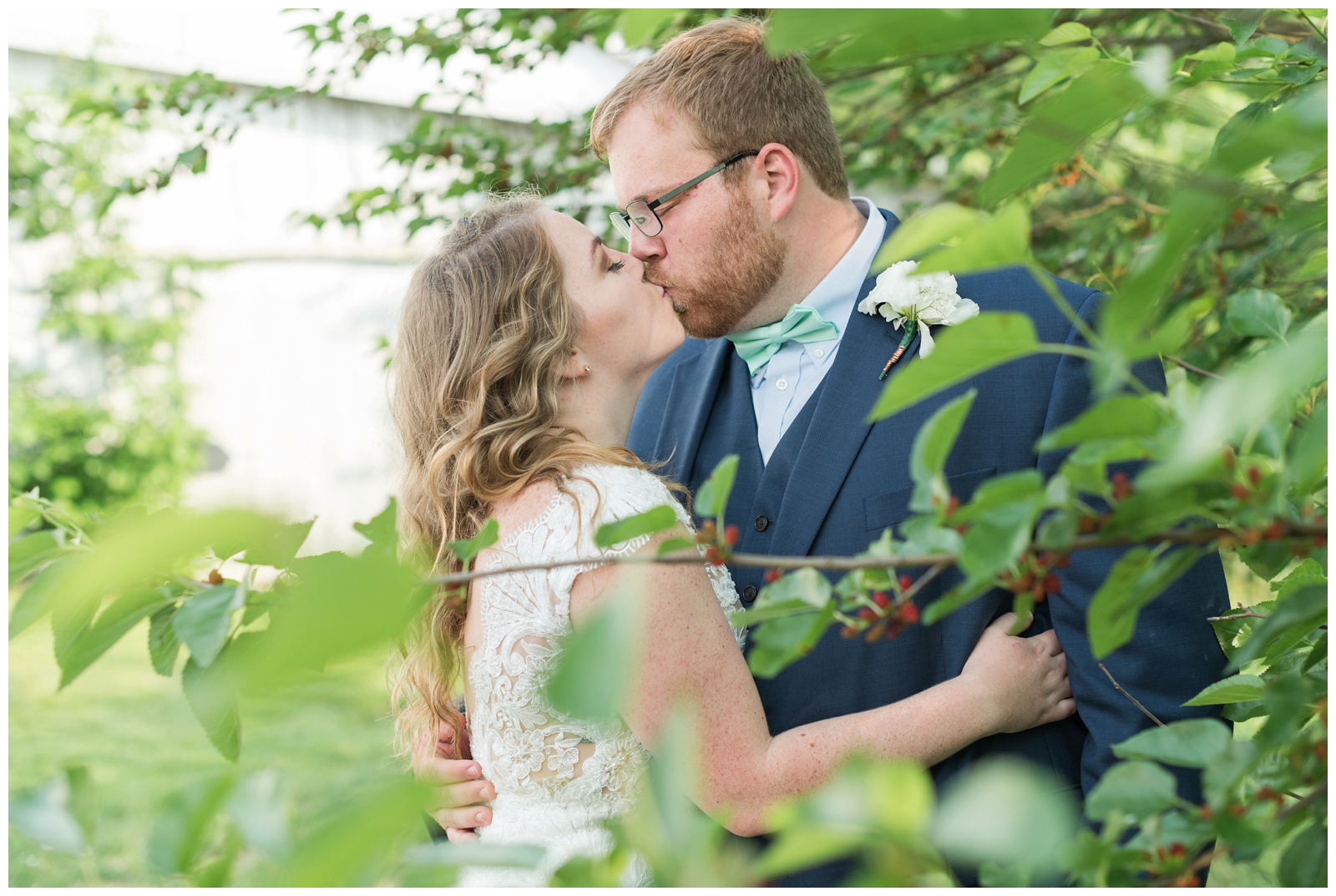 bride and groom kiss between trees at EagleSticks Golf Club