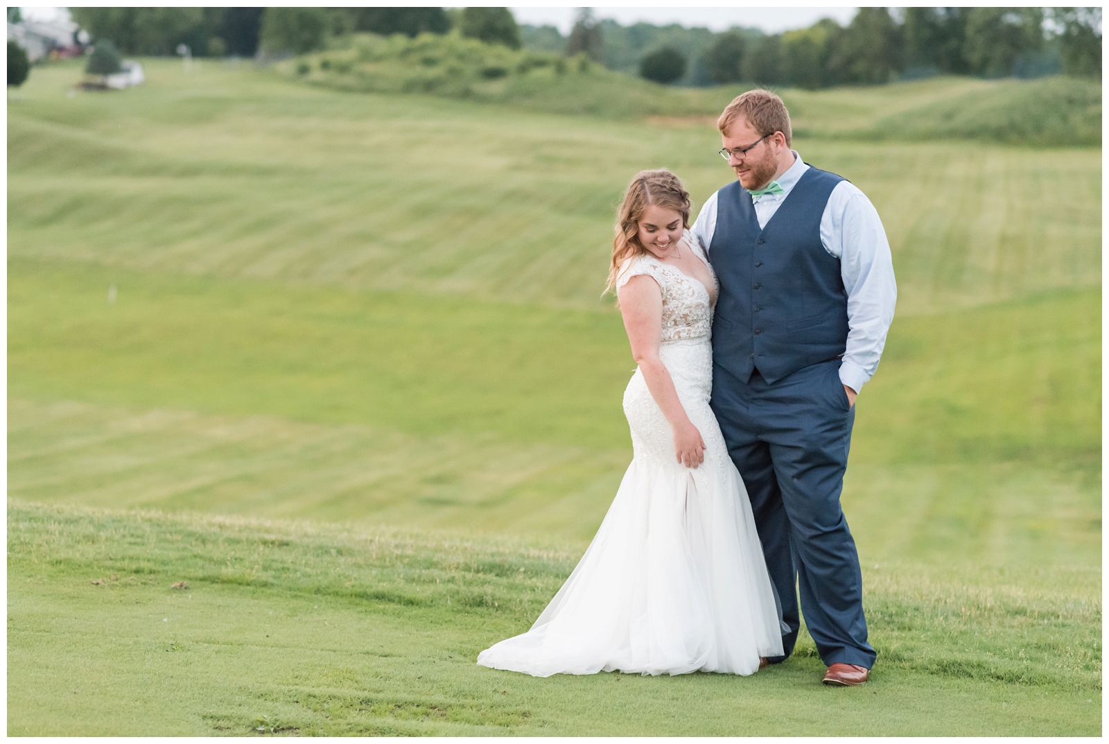 groom looks at new bride while holding her on the green at EagleSticks Golf Club