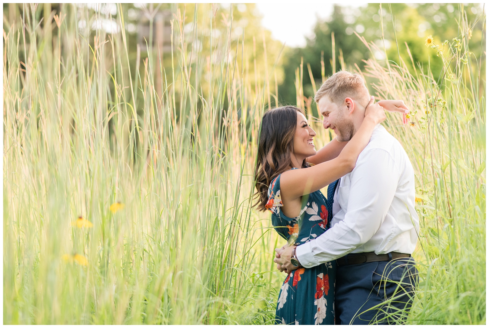 engaged couple surrounded by tall white, yellow and green prairie grasses at Inniswood metro gardens Engagement Session