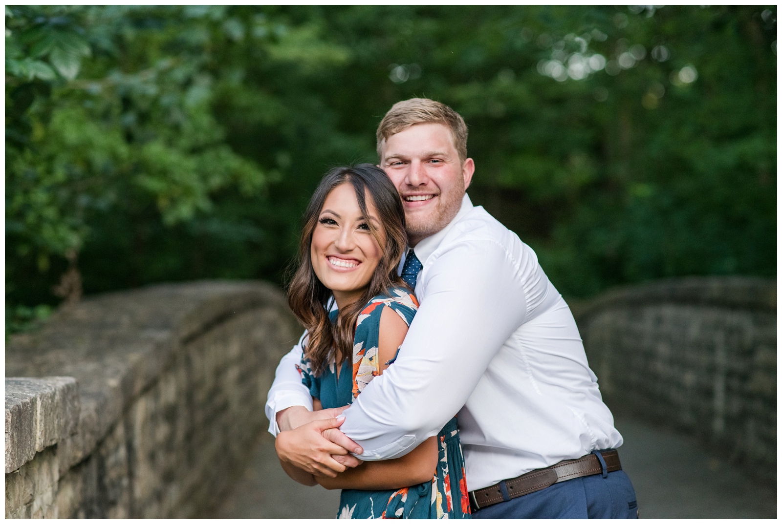 engaged man and women hugging each other on a stone bridge during engagement session 