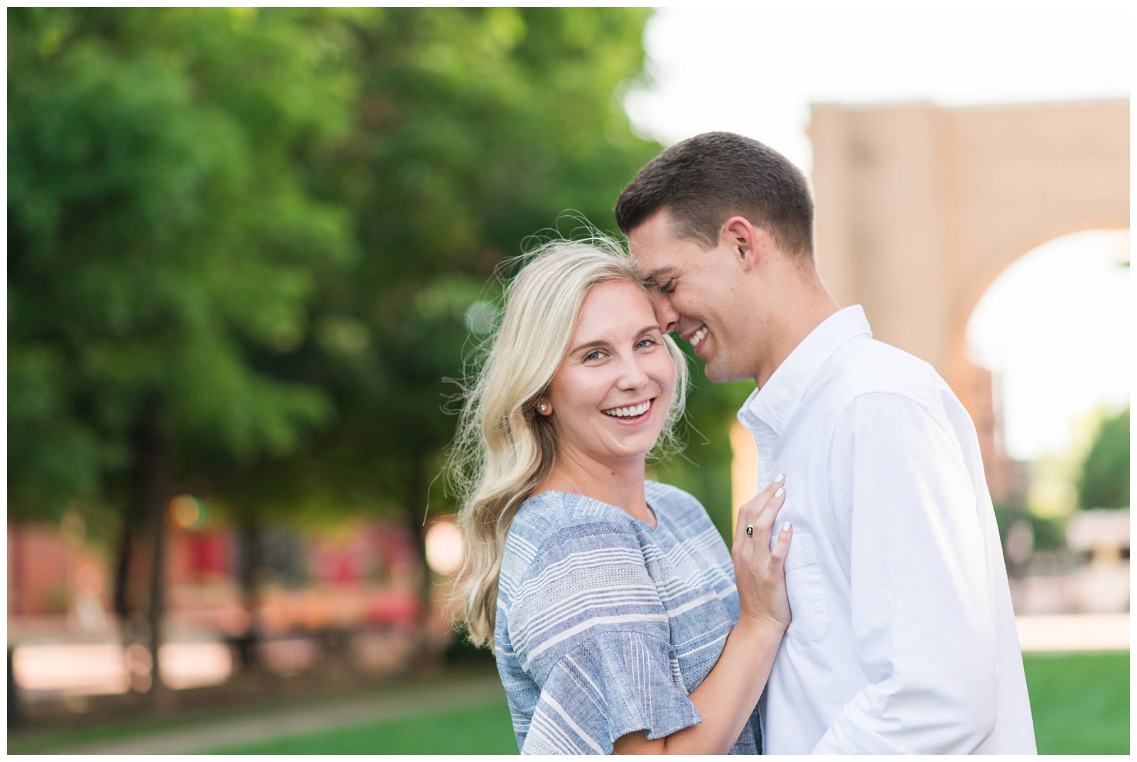 bride in blue dress and groom in white button down shirt snuggle during Ohio engagement portraits during the summer 