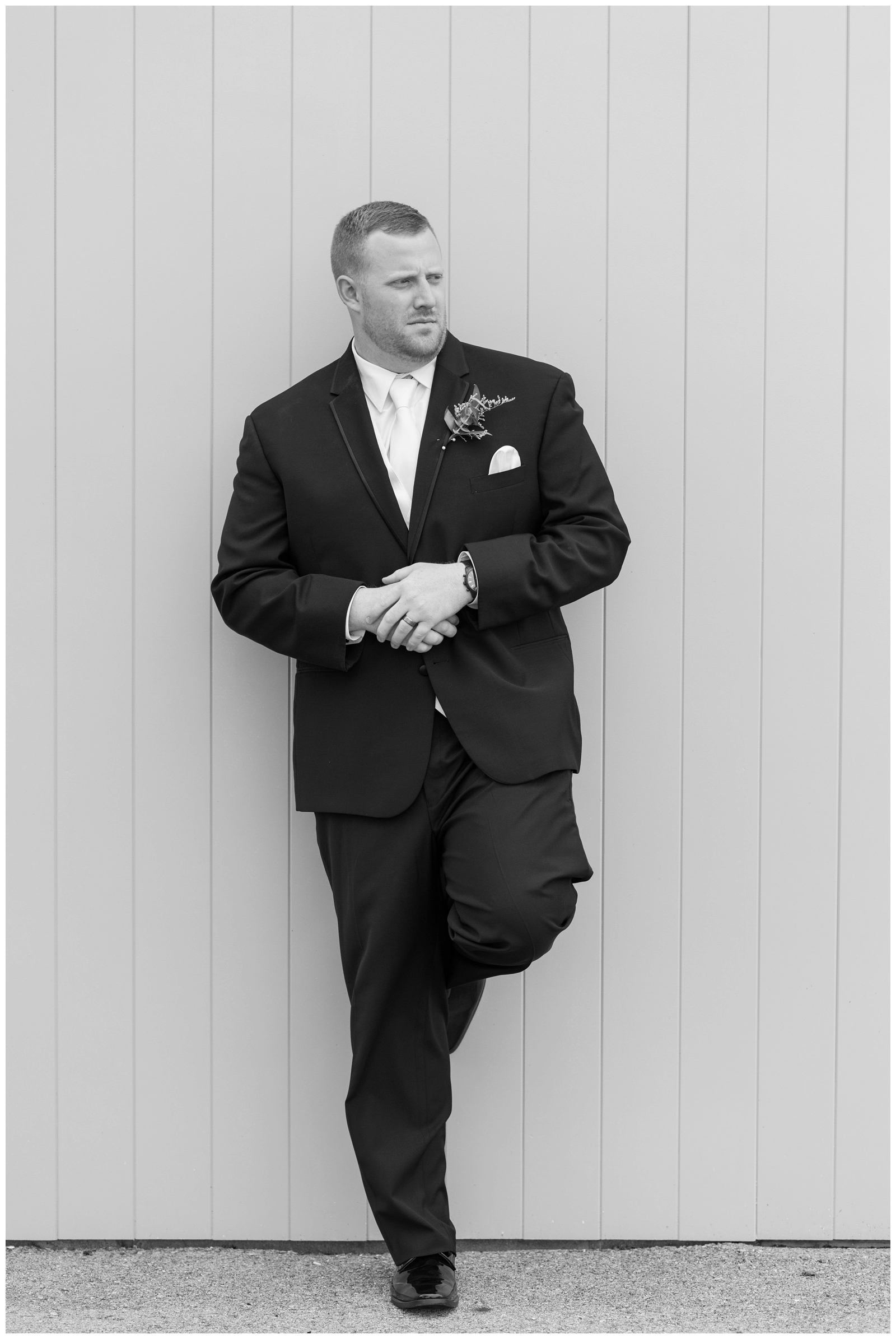 black and white groom's portrait at Pretty Prairie Farms with groom looking off into the distance 