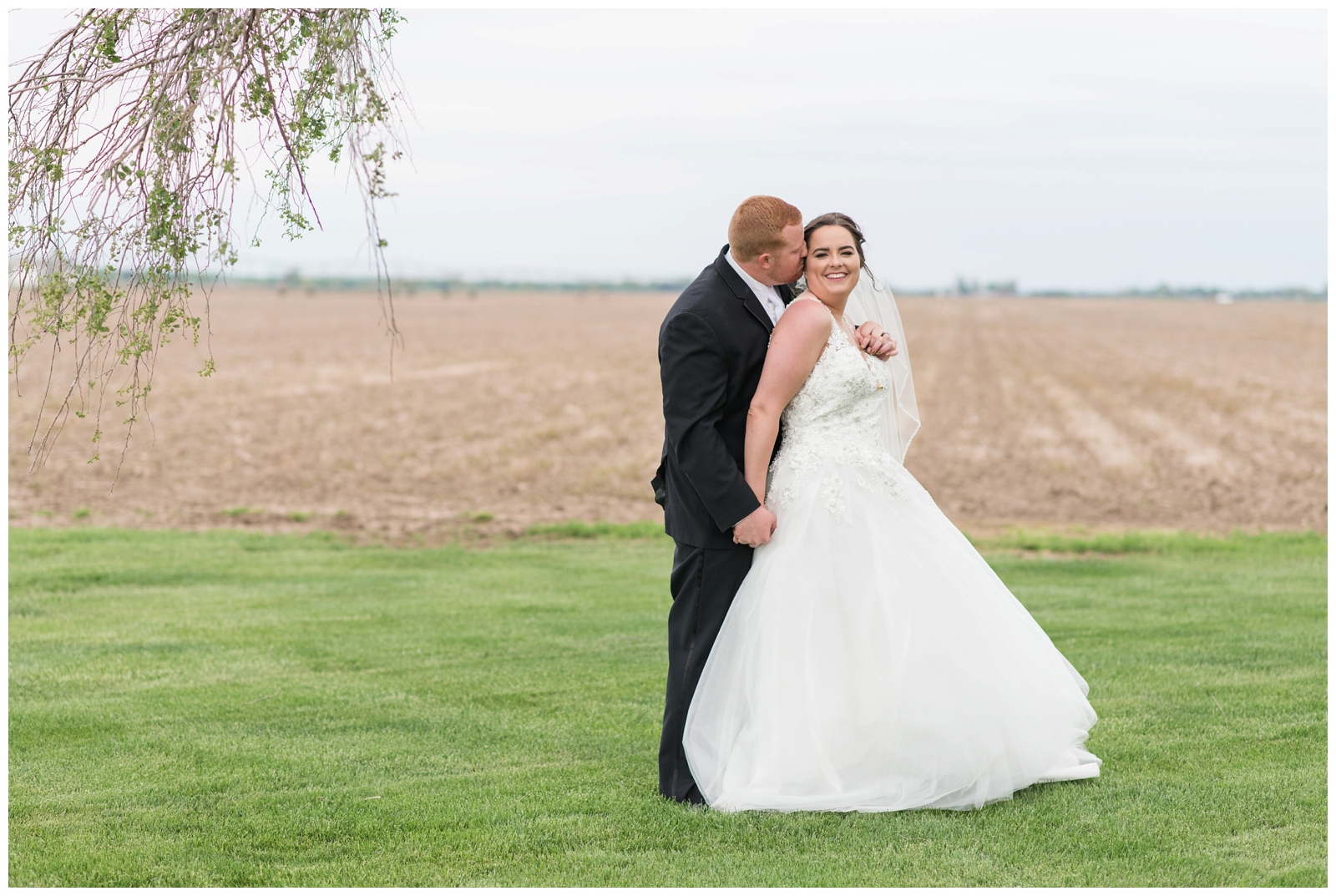 bride and groom cuddle during wedding portraits at Pretty Prairie Farms