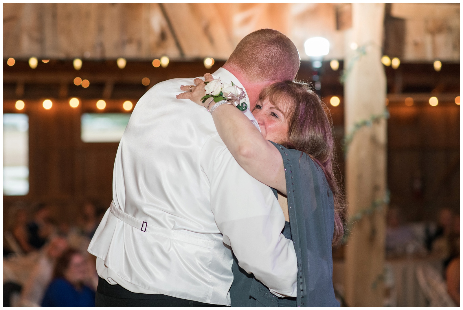 groom hugs mother during mother-son dance at wedding reception
