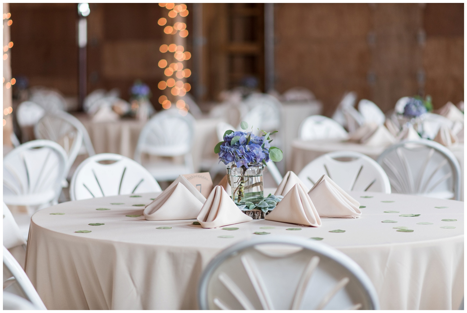 wedding reception in barn with pale blue floral centerpieces 
