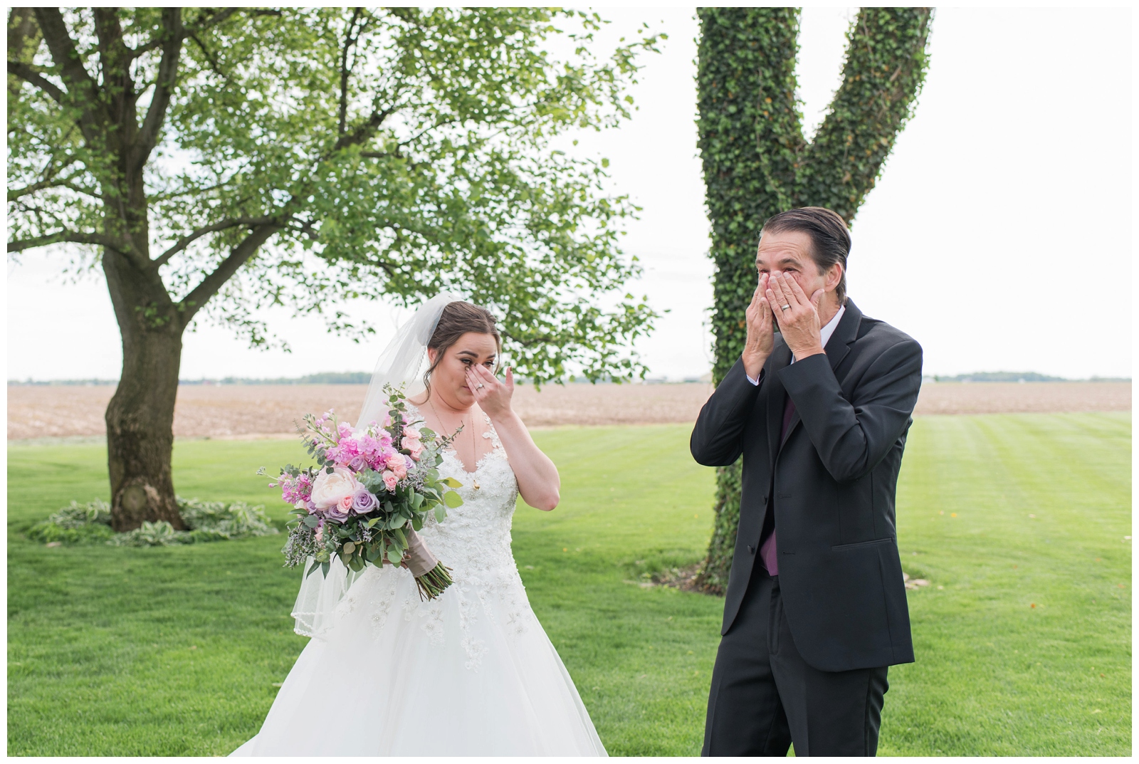 dad in black suit and bride with pink and purple bouquet cry during first look at Pretty Prairie Farms