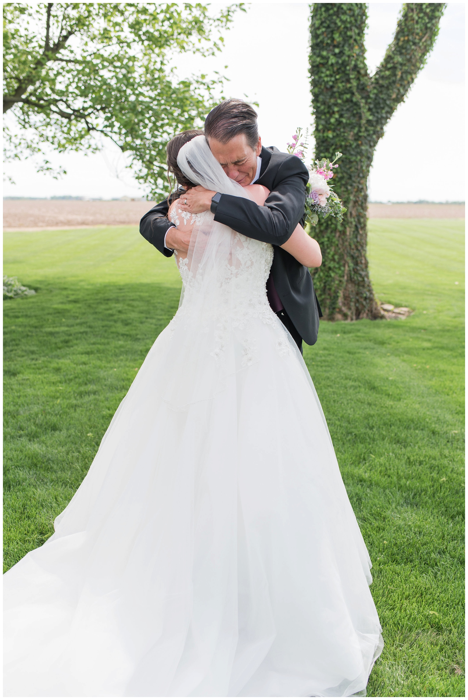 emotional father hugs bride on wedding day during first look