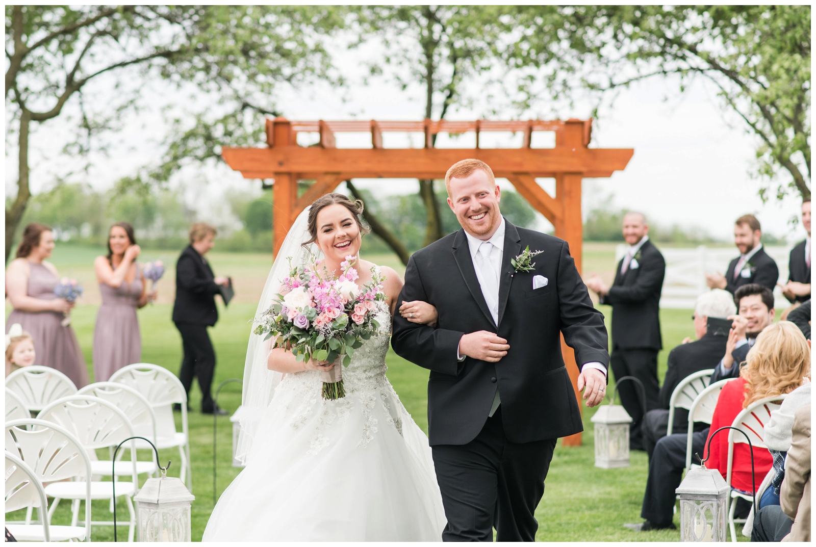 newly married couple walk up aisle at Pretty Prairie Farms wedding ceremony
