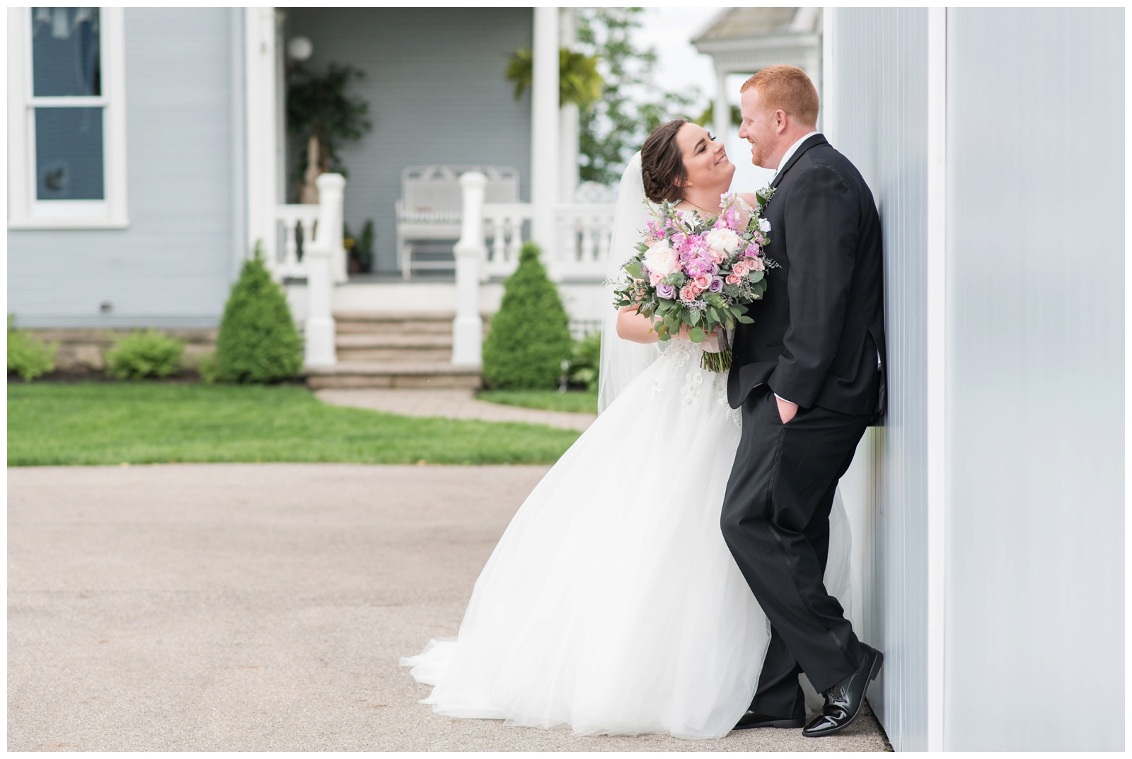 Bride and groom smile at each other during portraits at Pretty Prairie Farms