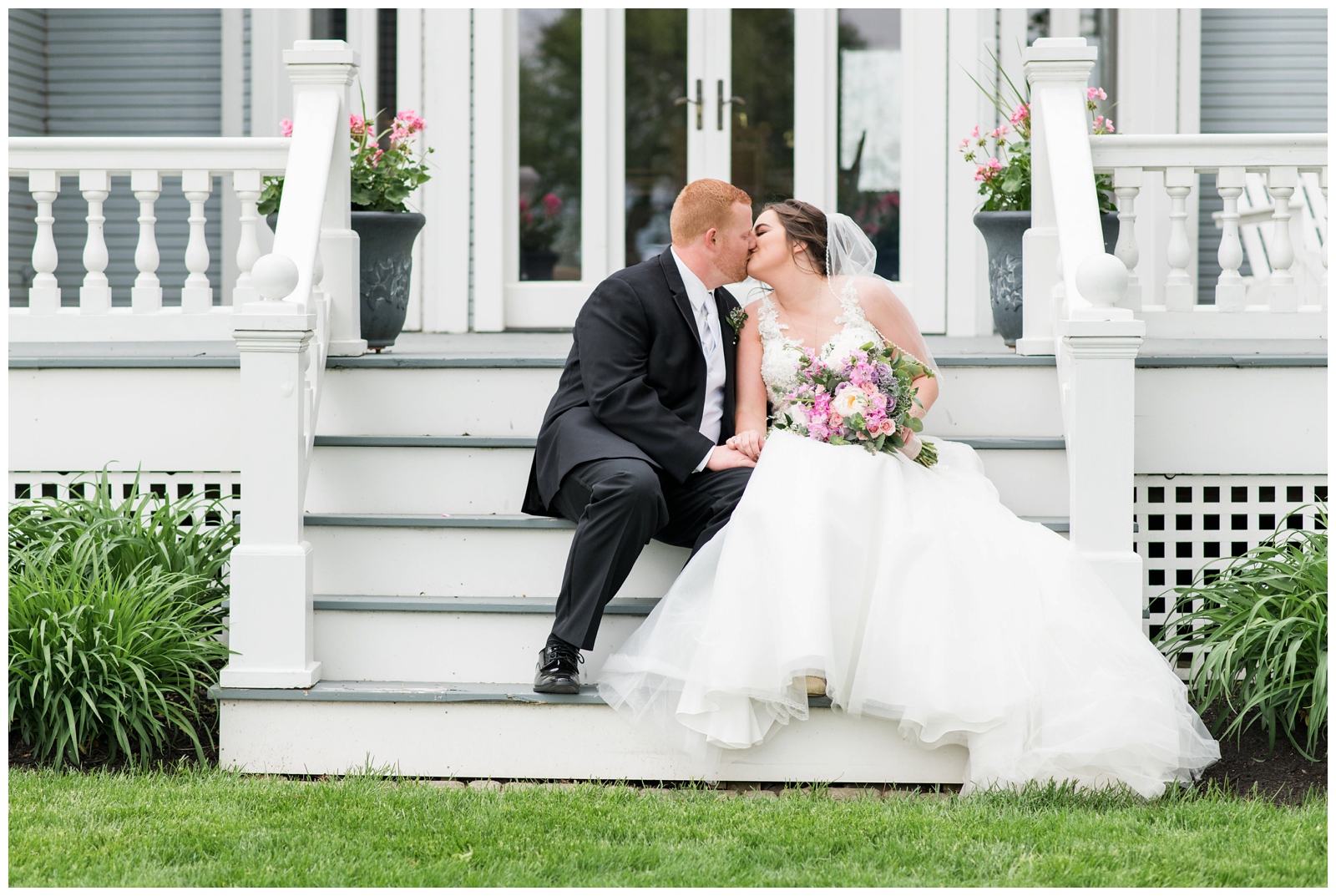 bride and groom kiss on steps of Pretty Prairie Farms farmhouse