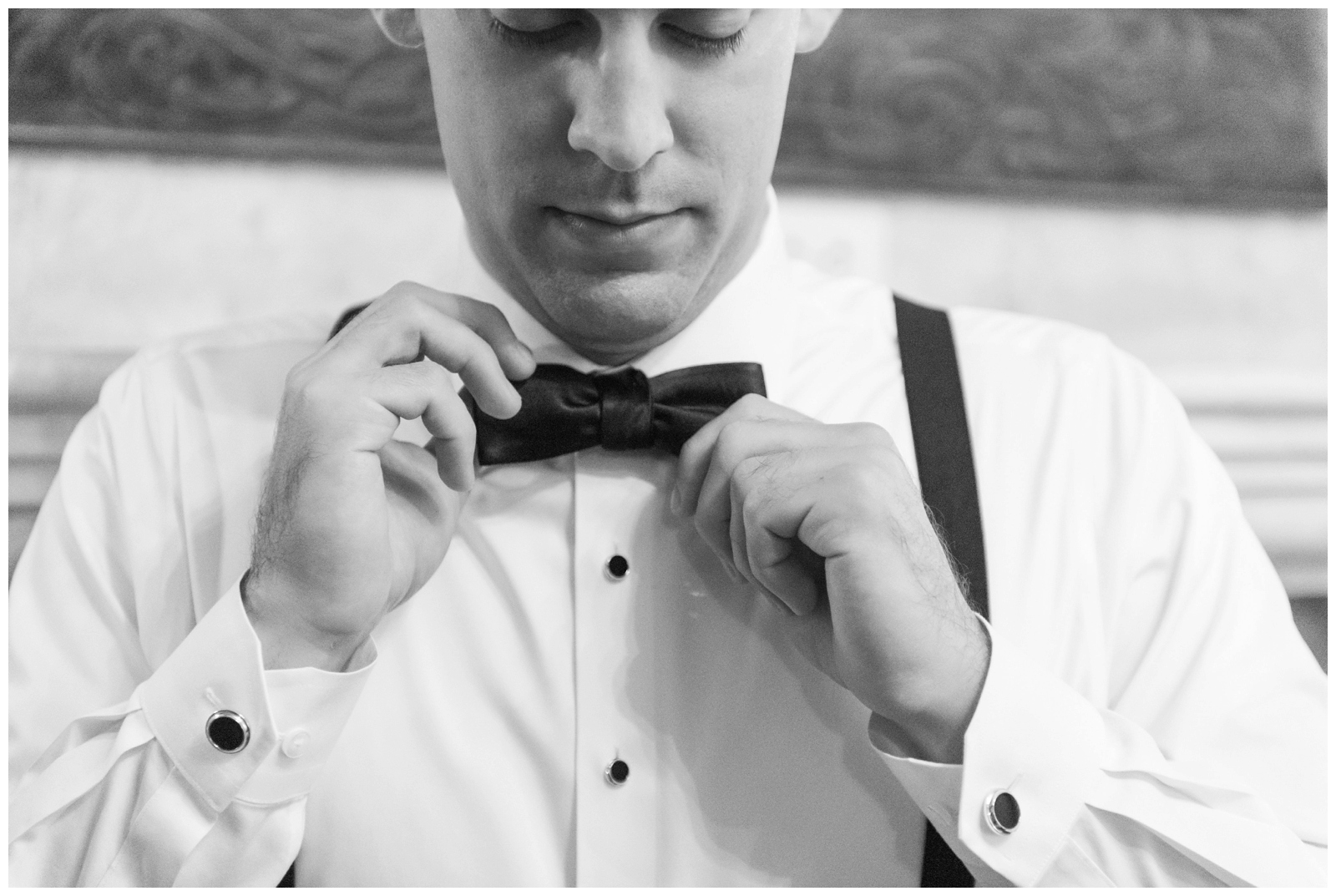 black and white portrait of groom adjusting tie for Gervasi Vineyards 