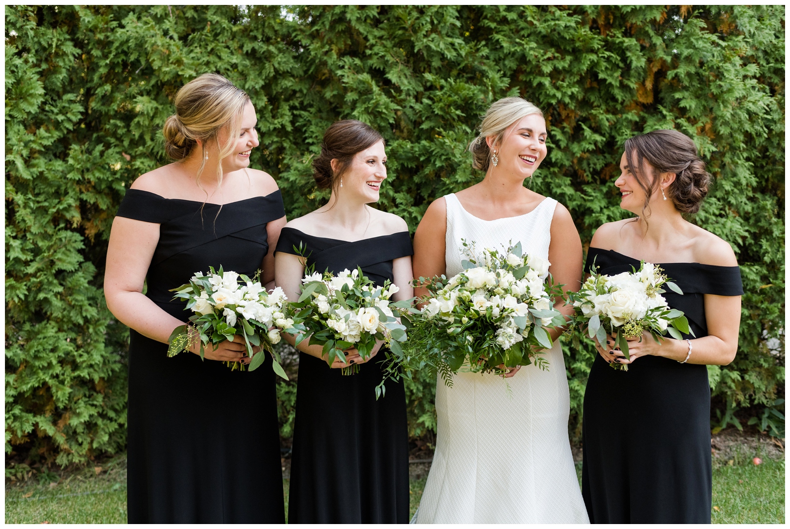 bridesmaids in off-the-shoulder black gowns pose at Gervasi Vineyard for Pipers Photography