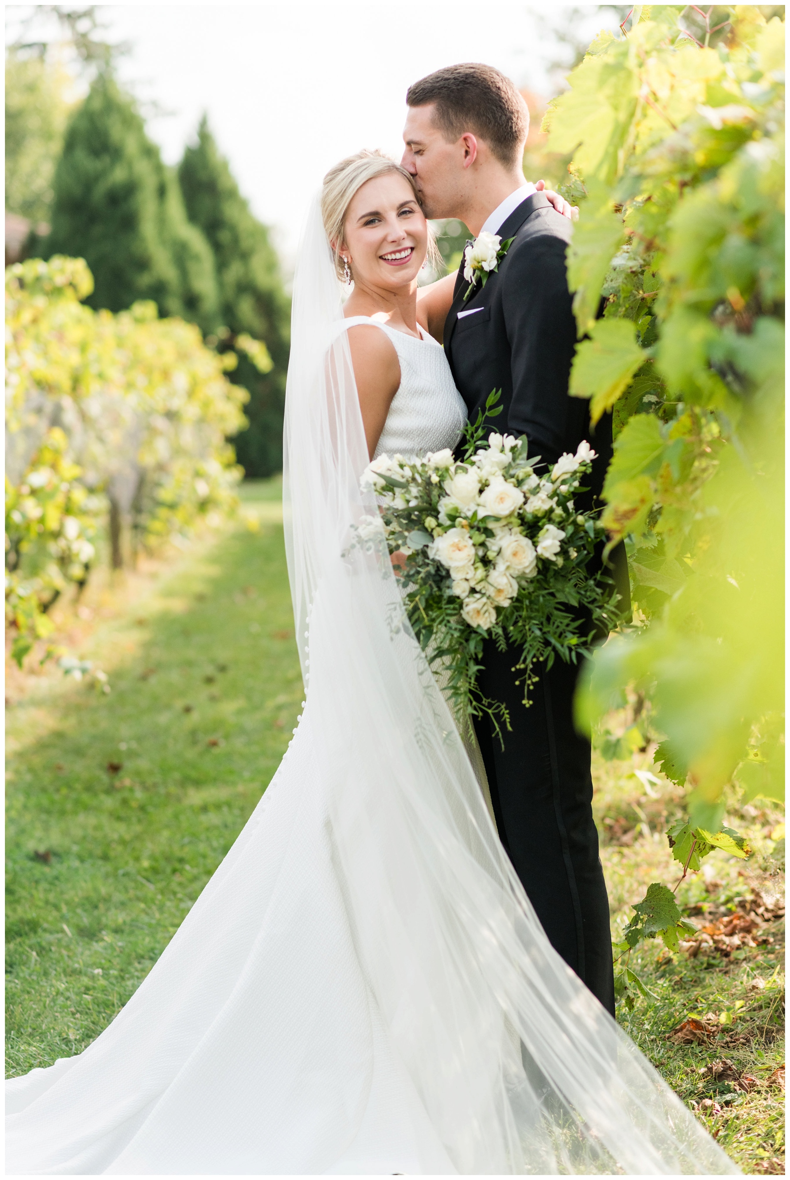 newly married couple poses in the grape vines during Ohio wedding portraits