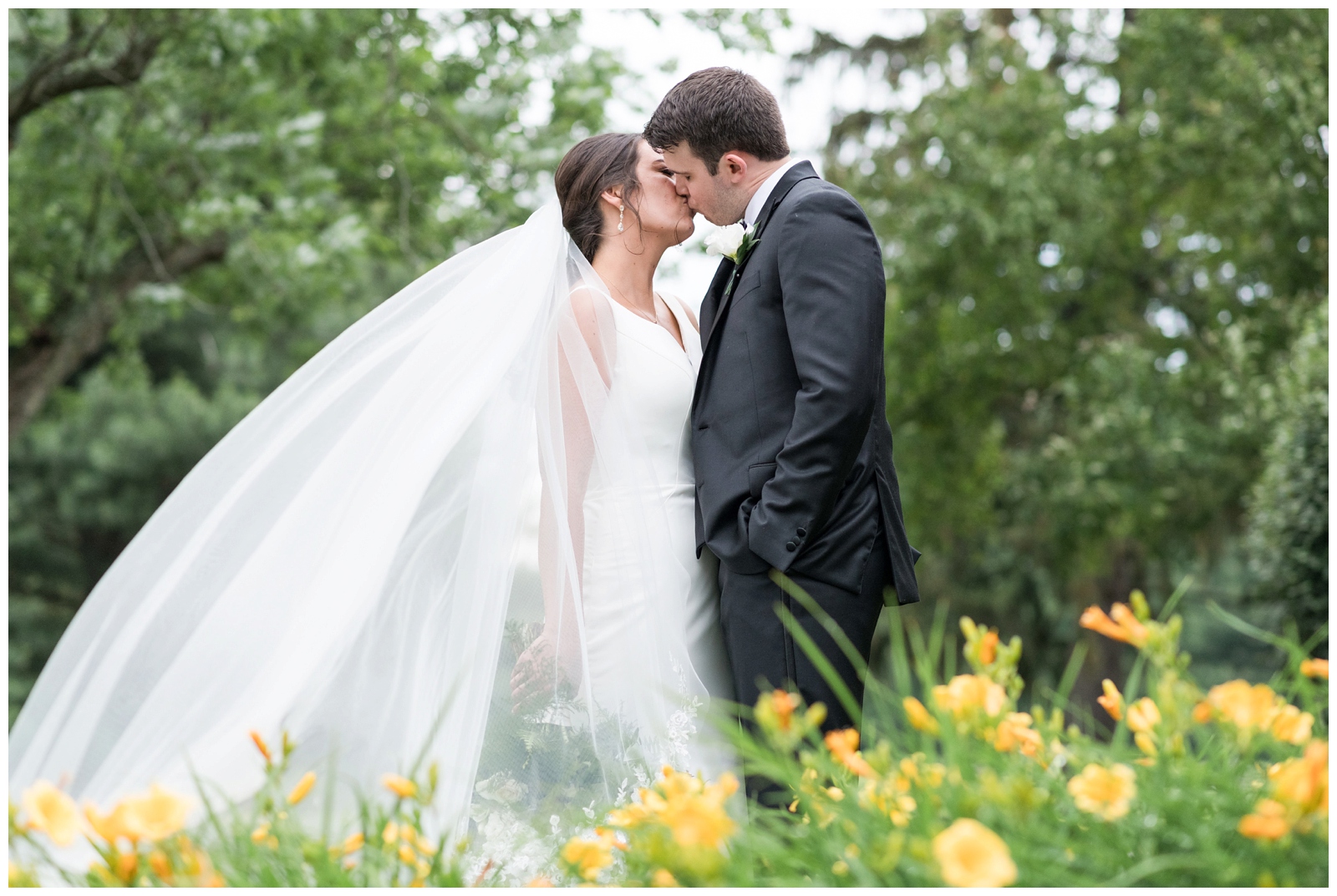 bride and groom kiss in garden of yellow flowers at Brookside Golf and Country Club 