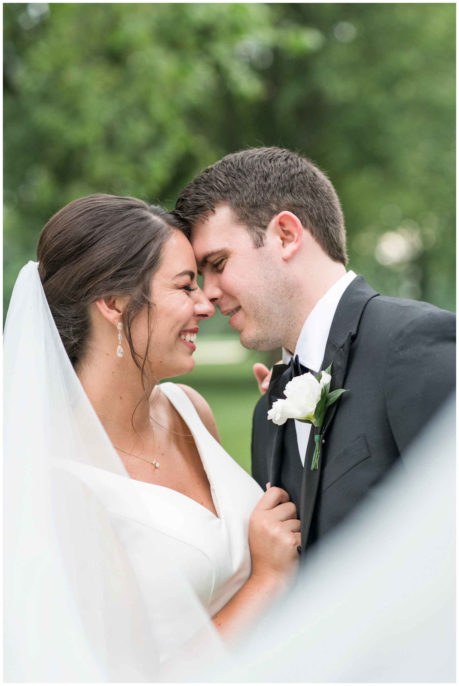 close up portrait of newlyweds at Brookside Golf and Country Club with bride's veil in bottom corner
