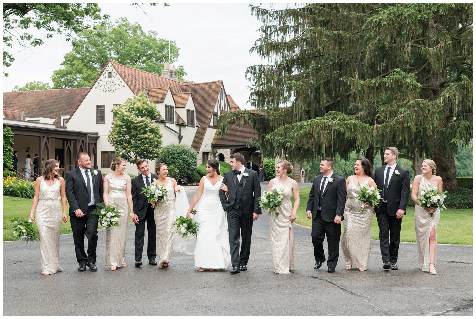 bridal party in gold gowns and black suits walks outside Ohio wedding venue Brookside Golf and Country Club 
