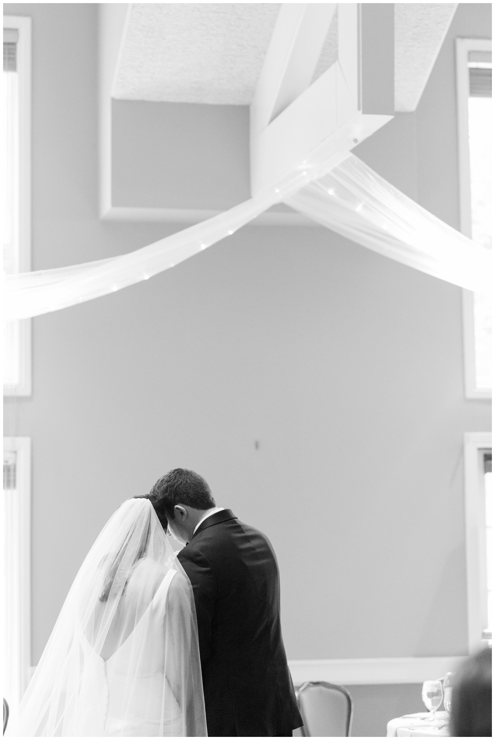 bride and groom pray while resting heads together during Columbus OH wedding ceremony
