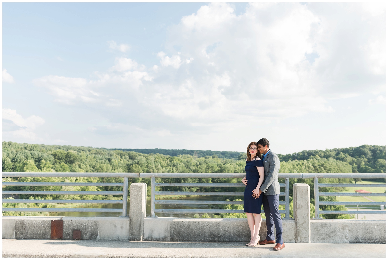 bride in navy dress and groom in gray suit embrace on Hoover Reservoir