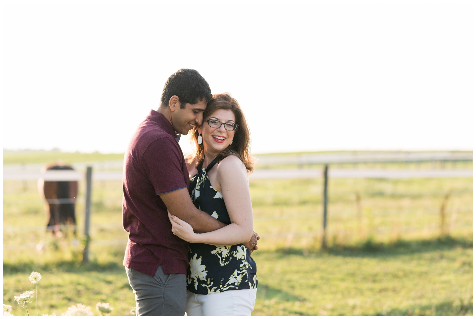 engagement portraits in horse field with casual outfits on bride and groom by Pipers Photography