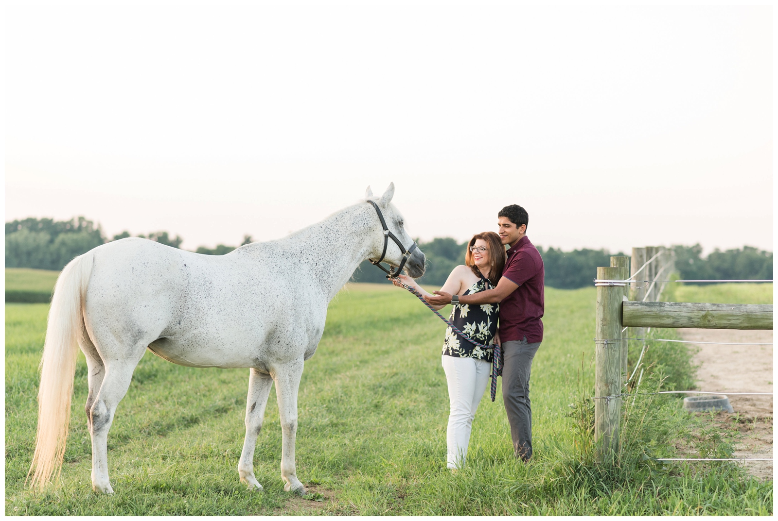 bride and groom pet white horse during engagement photos in Ohio field