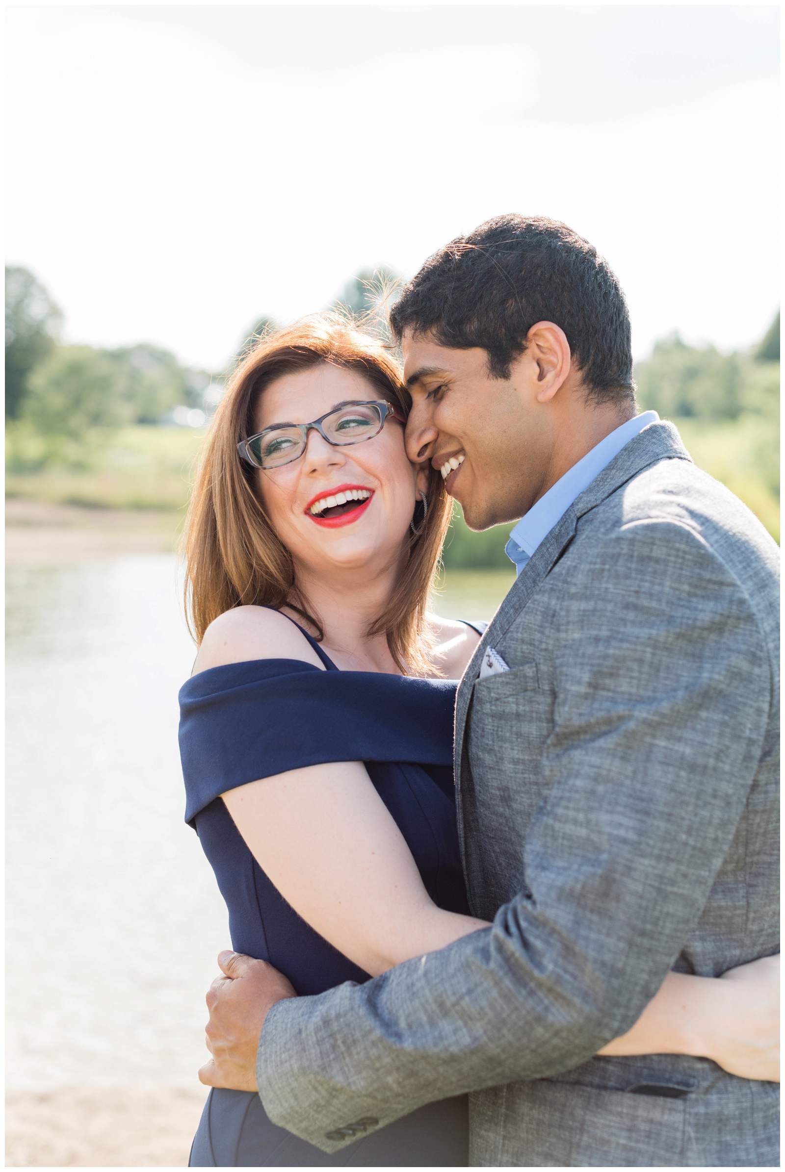 close up portrait of couple laughing together in navy blue and grey during Hoover Reservoir engagement session