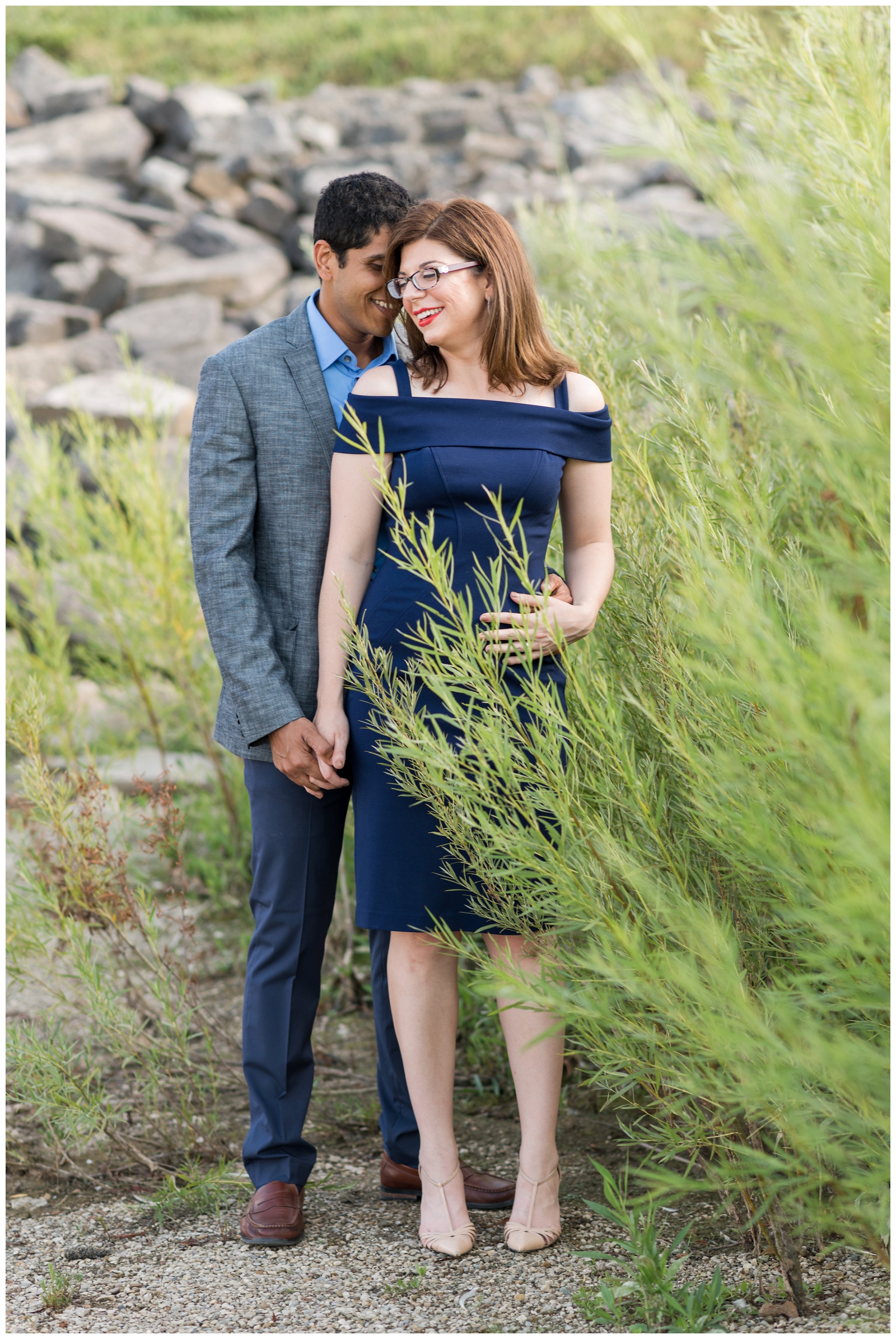 bride and groom romantically pose in the greenery along Hoover Reservoir in Ohio during engagement portraits