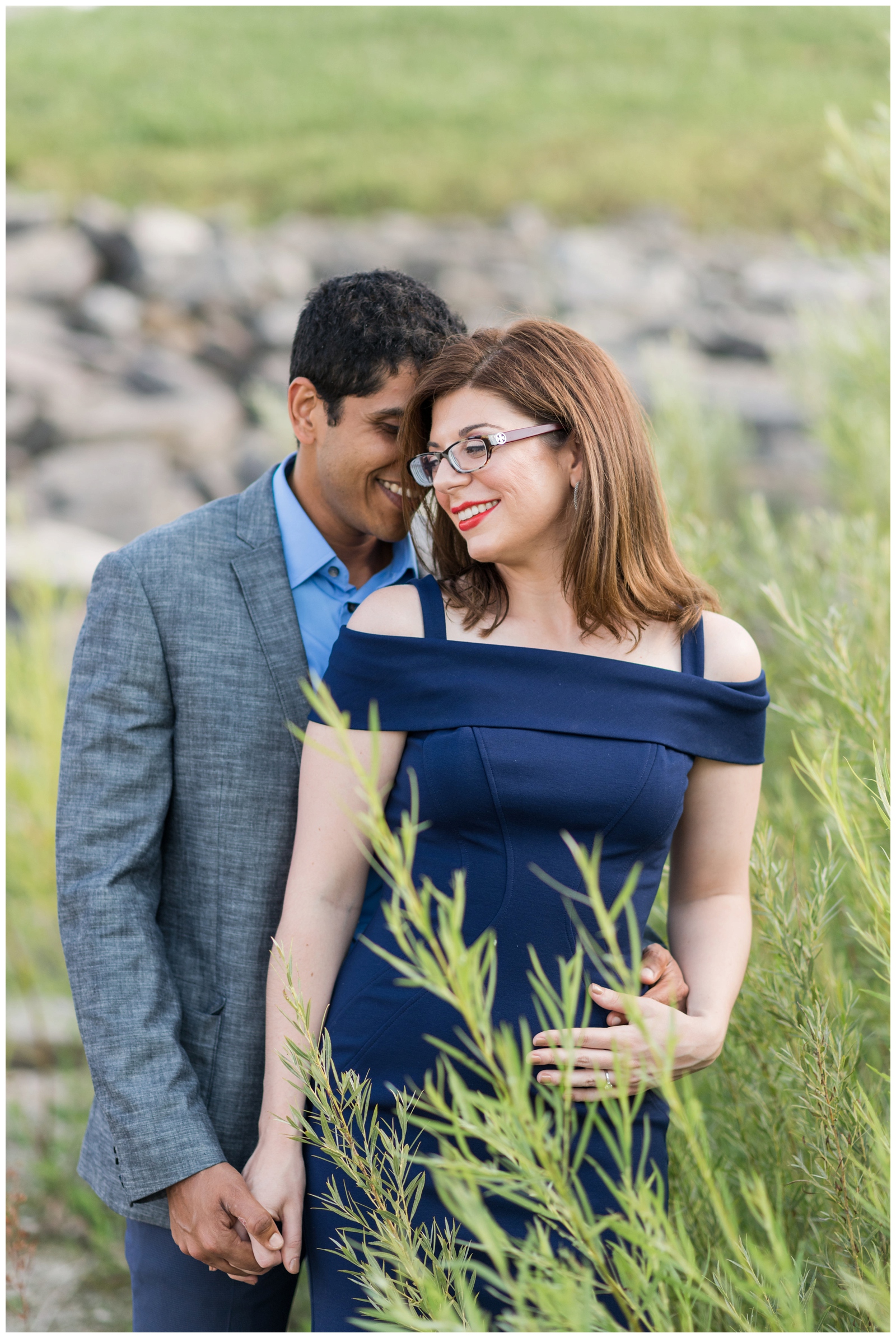 groom hugs bride from behind in field during Westerville OH engagement portraits