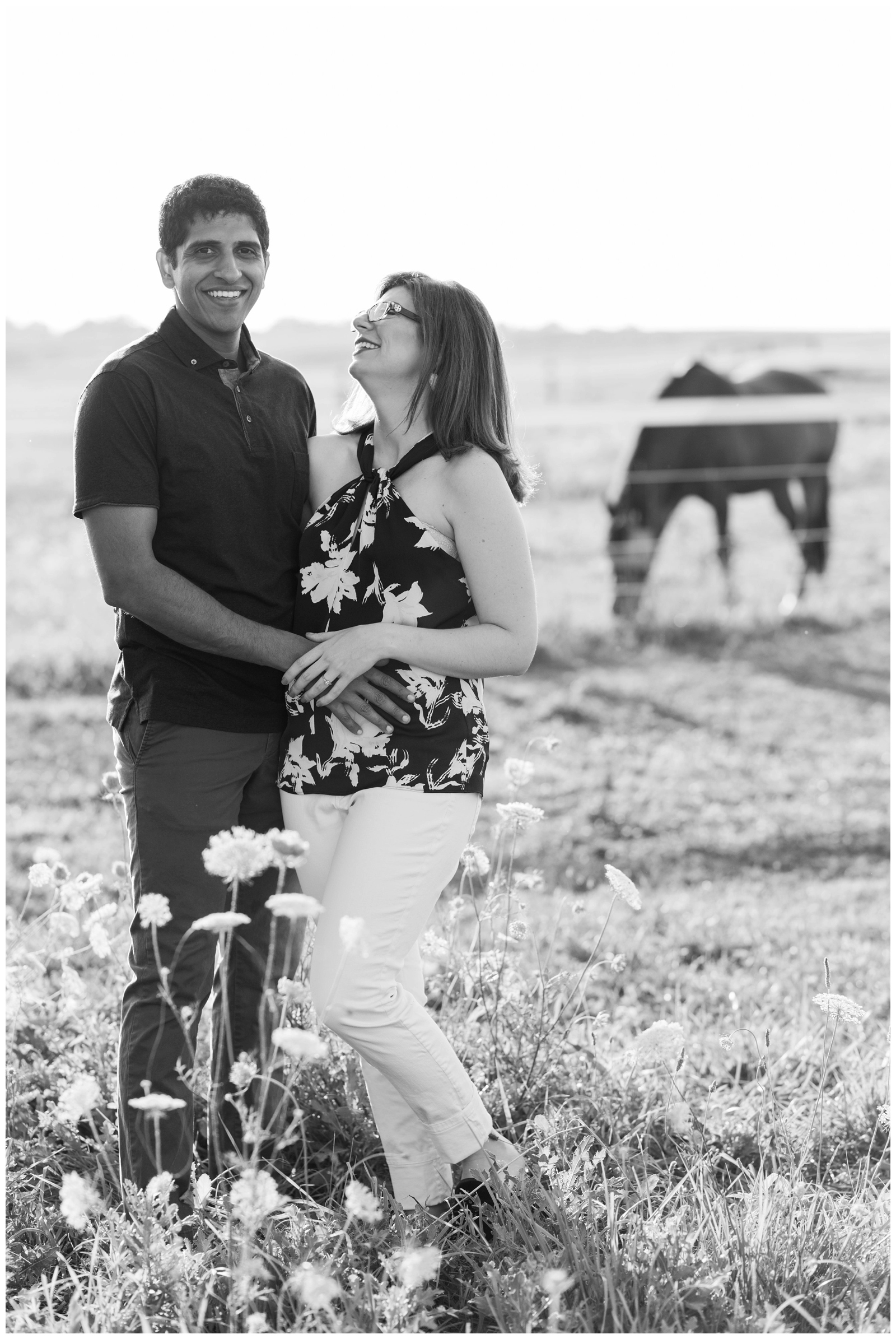 bride grins up at groom during engagement portraits in horse field in Ohio with Pipers Photography