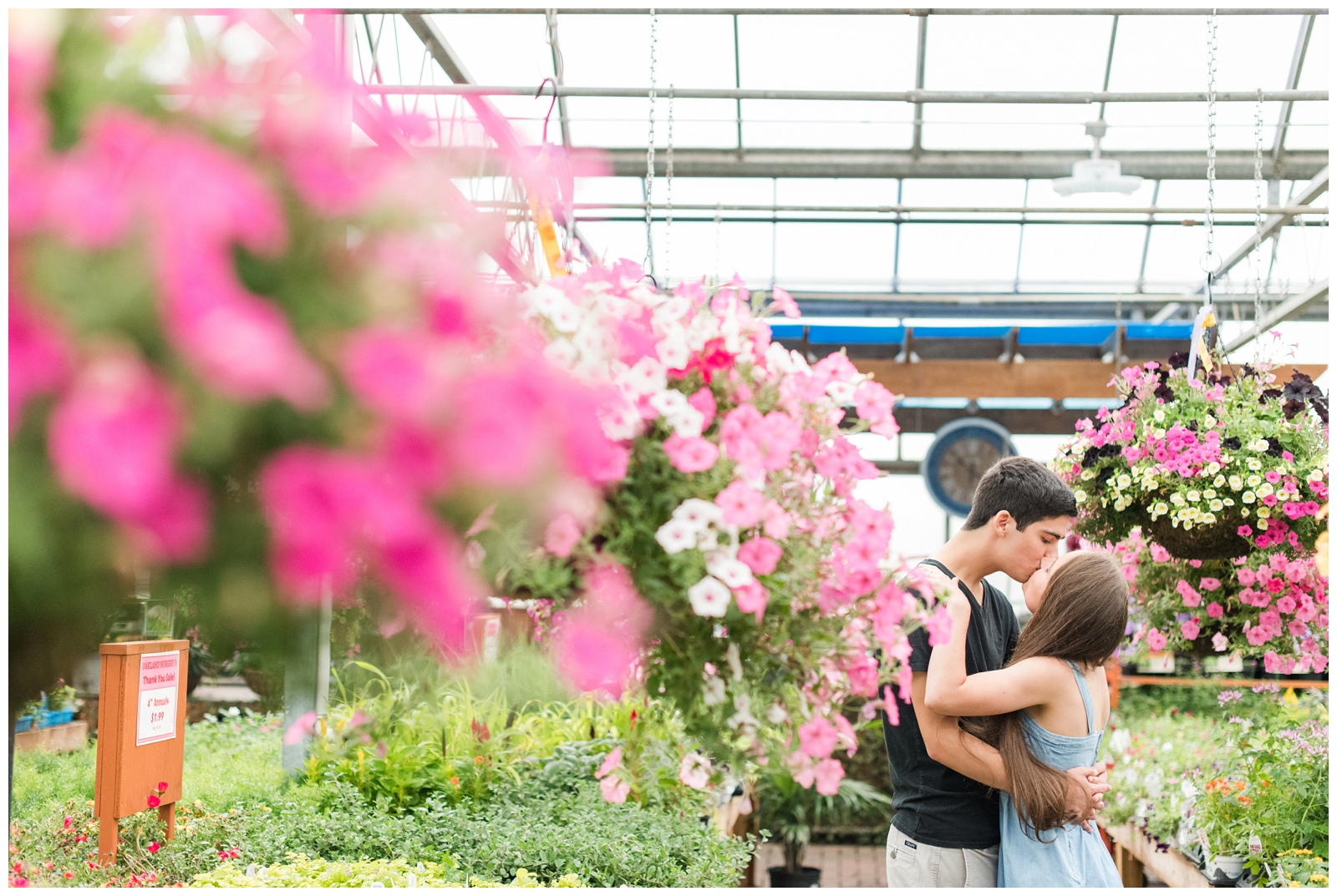 bride and groom kiss among bright pink flowers in New Albany OH greenhouse engagement session